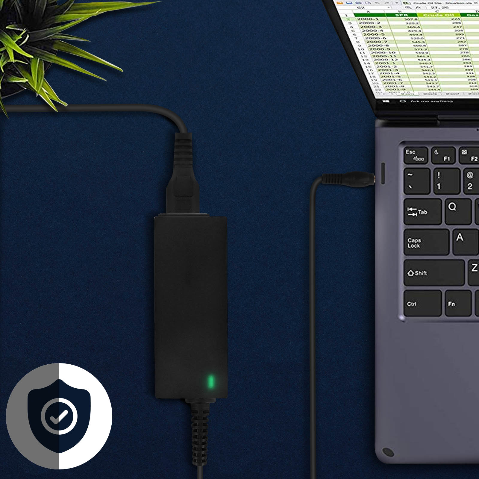 Adaptador de corriente negro con luz verde conectado a un portátil sobre fondo azul.