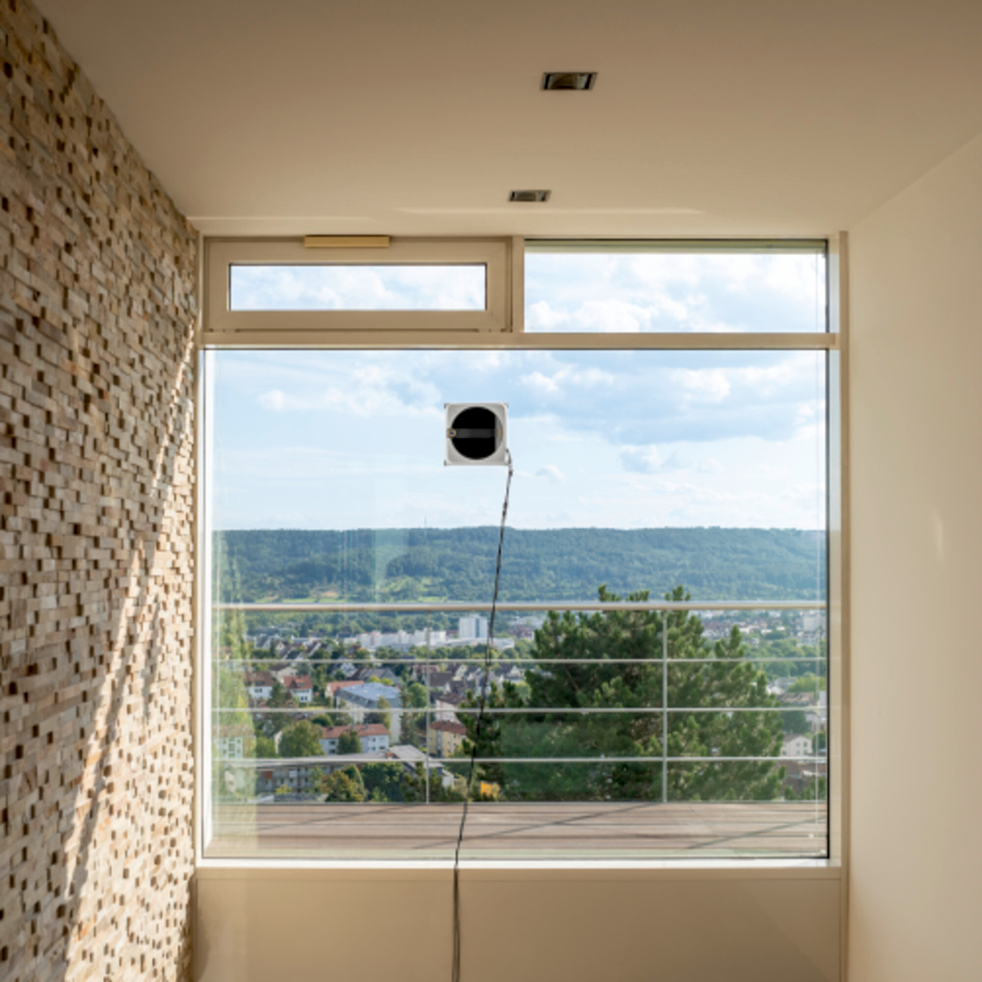 Un robot lavavetri pulisce una grande finestra con vista su una città.