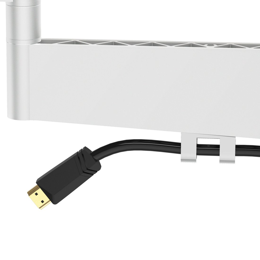 Czarny kabel HDMI ze złotym złączem przechodzi przez biały klips na srebrnym ramieniu monitora.