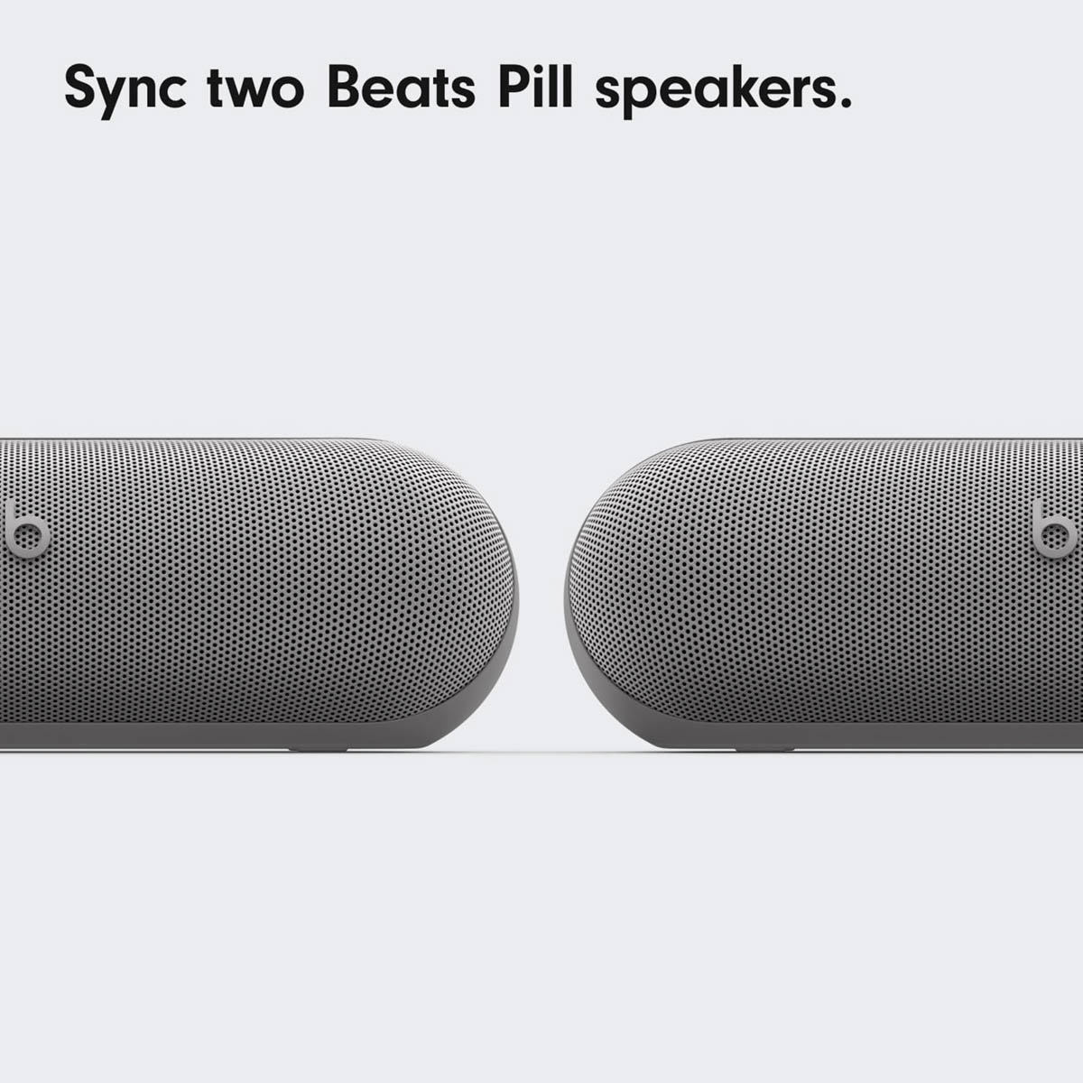 Zwei graue Beats Pill Lautsprecher nebeneinander auf weißem Hintergrund.