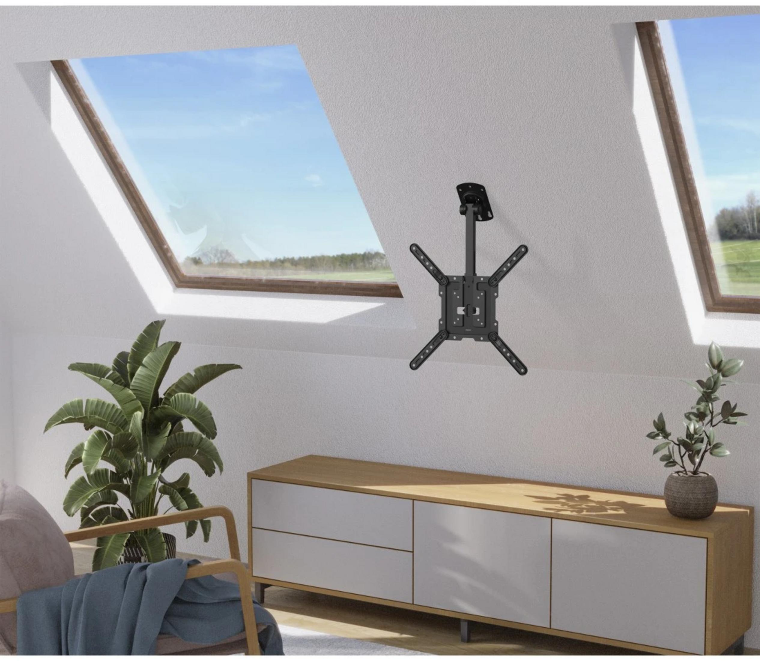 Czarny uchwyt sufitowy do telewizorów nad drewnianą szafką z roślinami.