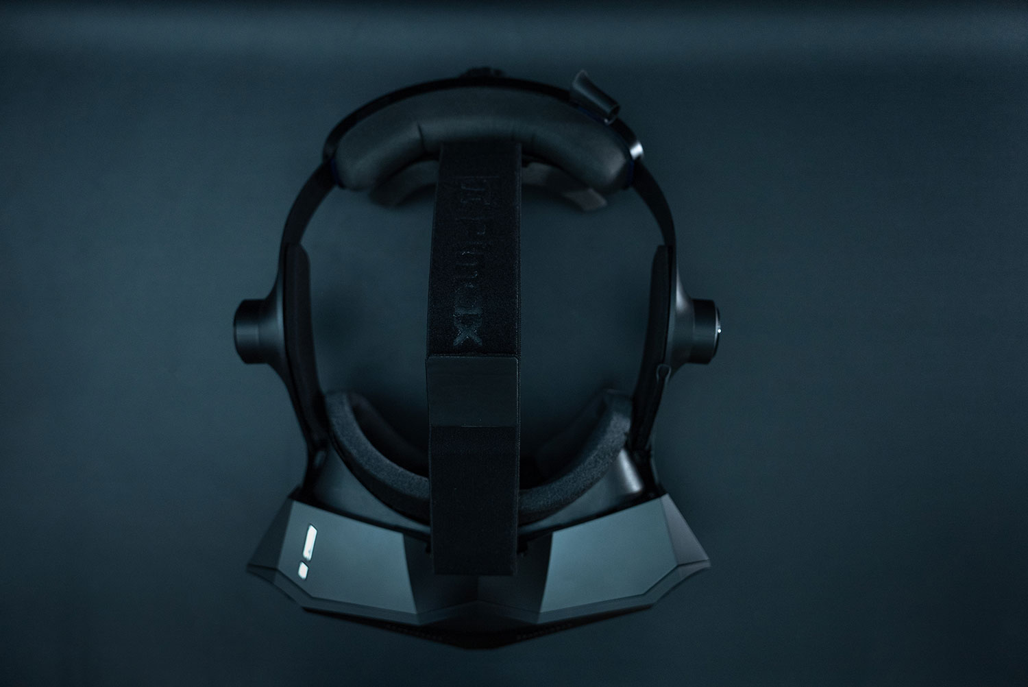 Visor VR negro con diadema y acolchado, sobre fondo oscuro.