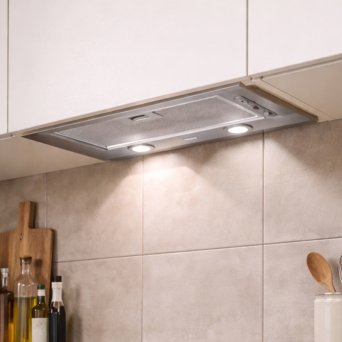 Campana extractora de acero inoxidable con luces sobre azulejos beige.
