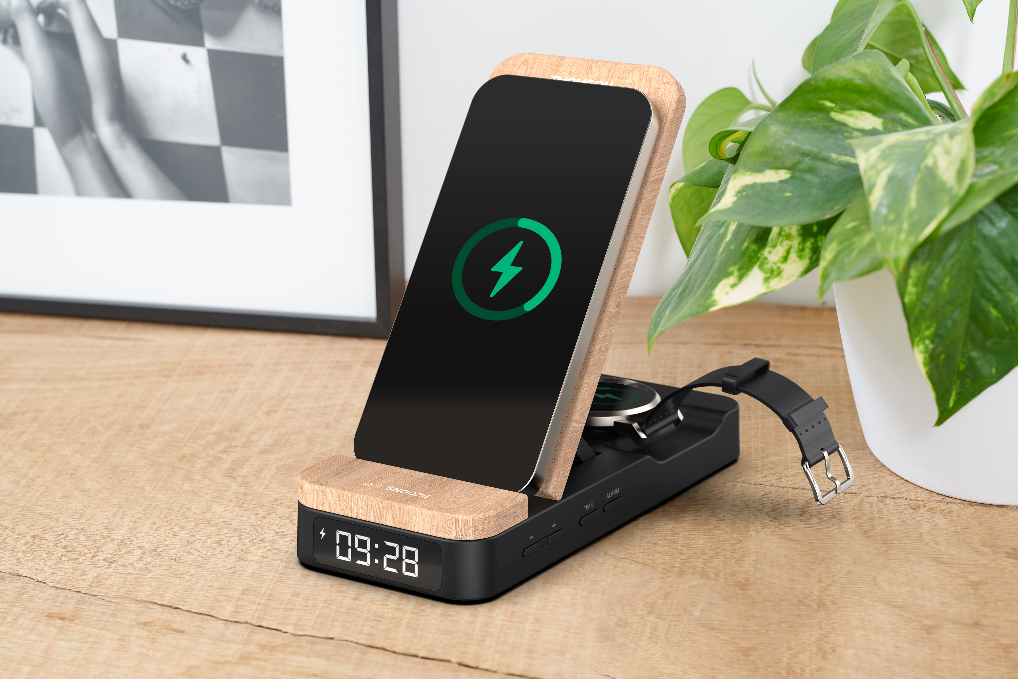 Ładowarka do telefonu z telefonem, zegarkiem i rośliną na drewnianym stole.