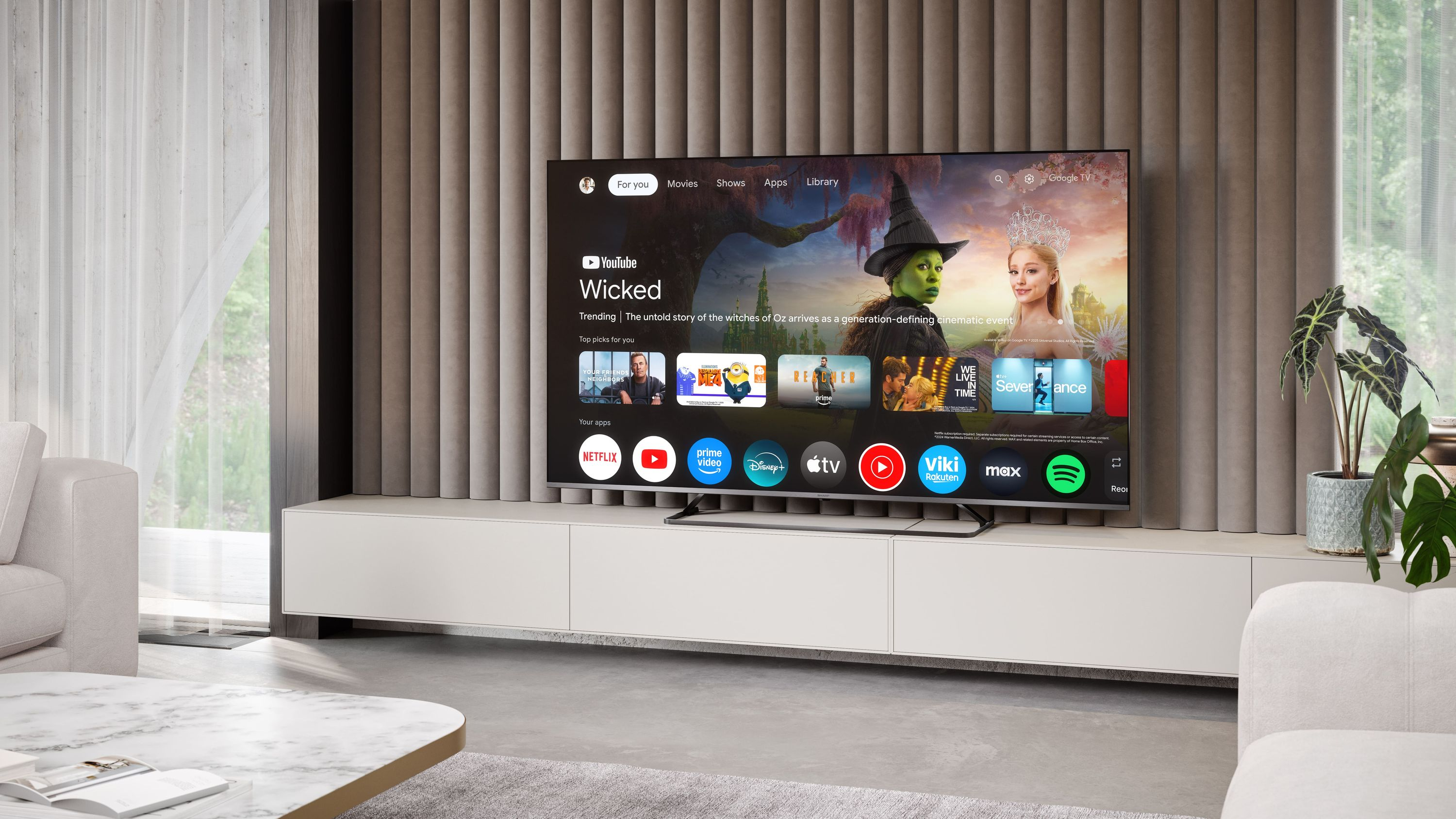 Una TV moderna mostra l'app 'Wicked' con streghe e una principessa.
