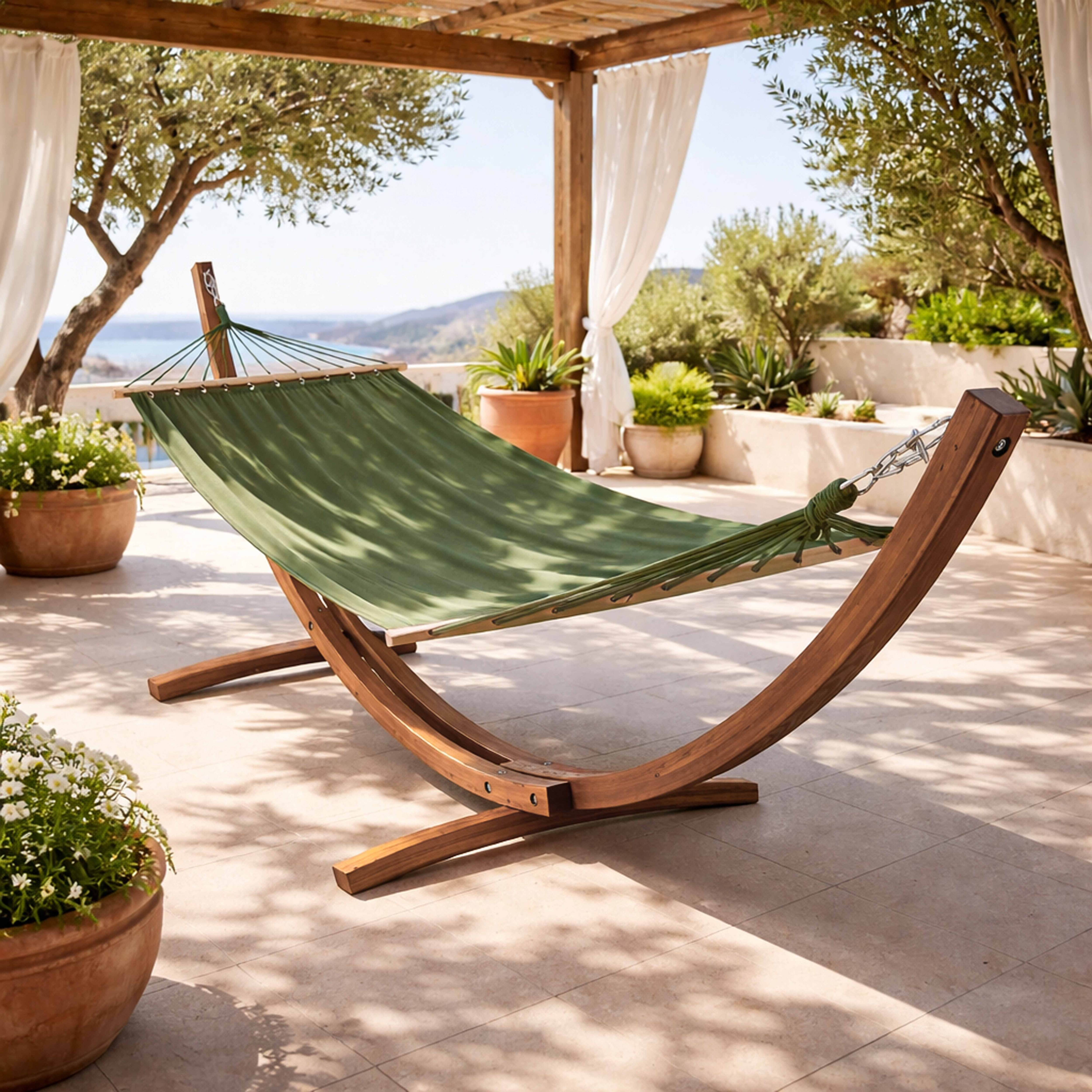Eine grüne Hängematte auf einem Holzständer unter einer Pergola mit Blick aufs Meer.