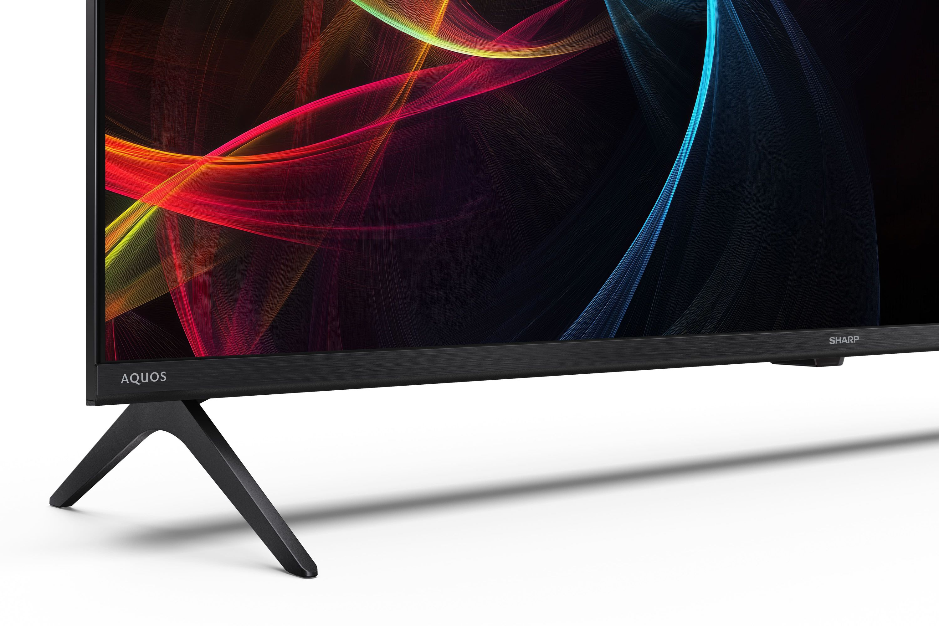 Un televisor moderno con un patrón abstracto colorido y un soporte negro.