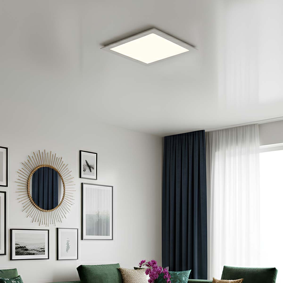 Una luz de techo rectangular ilumina una sala con arte de pared y cortinas.