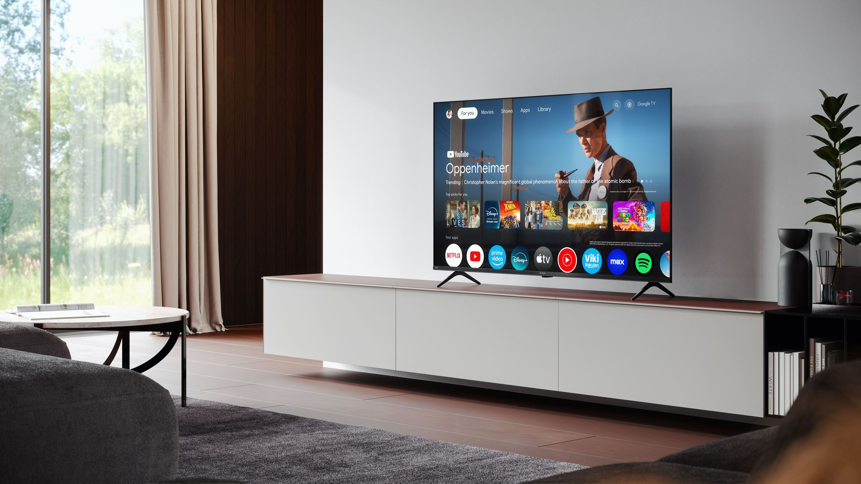 Ein moderner Wohnraum mit einem großen Fernseher, der Google TV mit Oppenheimer zeigt.