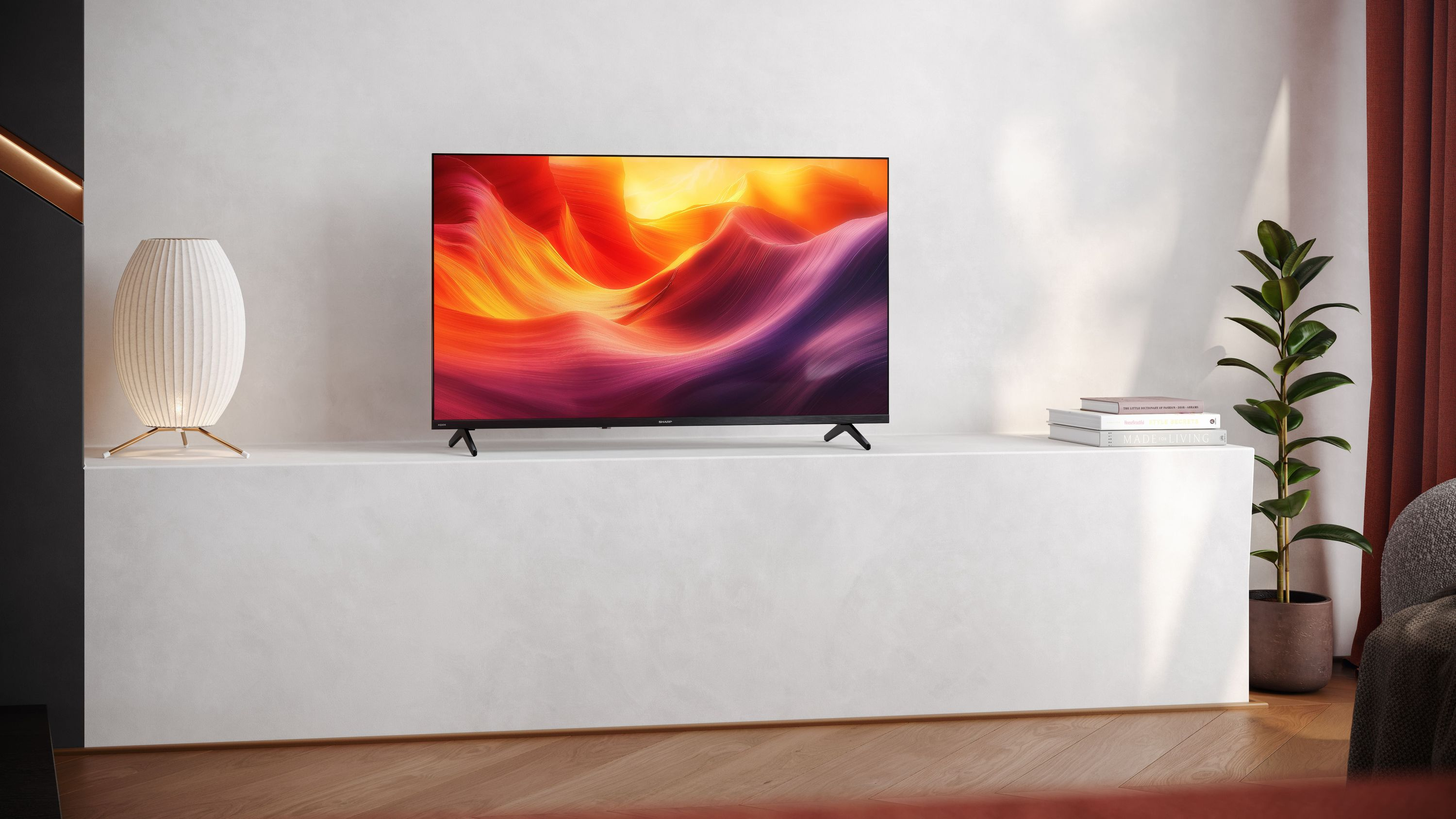 Ein moderner Fernseher mit einem bunten Bild steht auf einem weißen Sideboard neben einer Lampe.