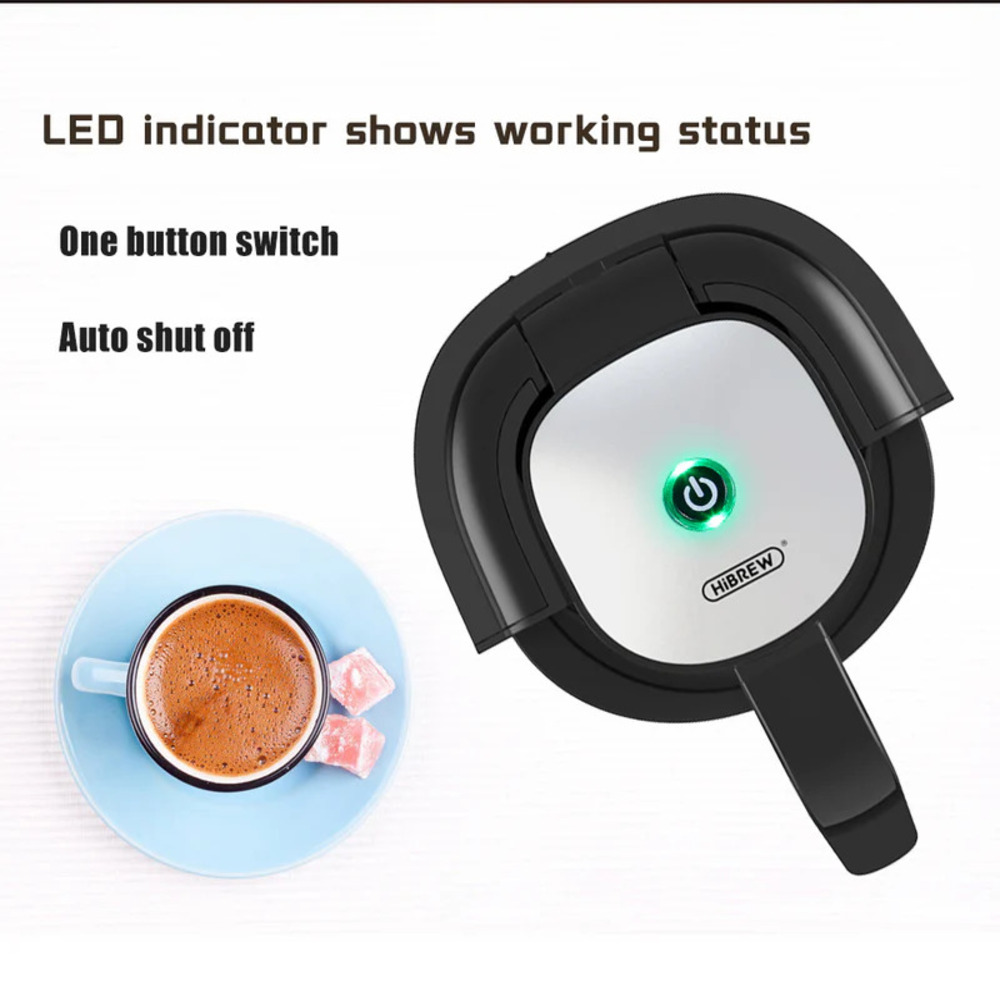 Kaffeemaschine mit grünem Power-Knopf, daneben eine Tasse Kaffee und Süßigkeiten.