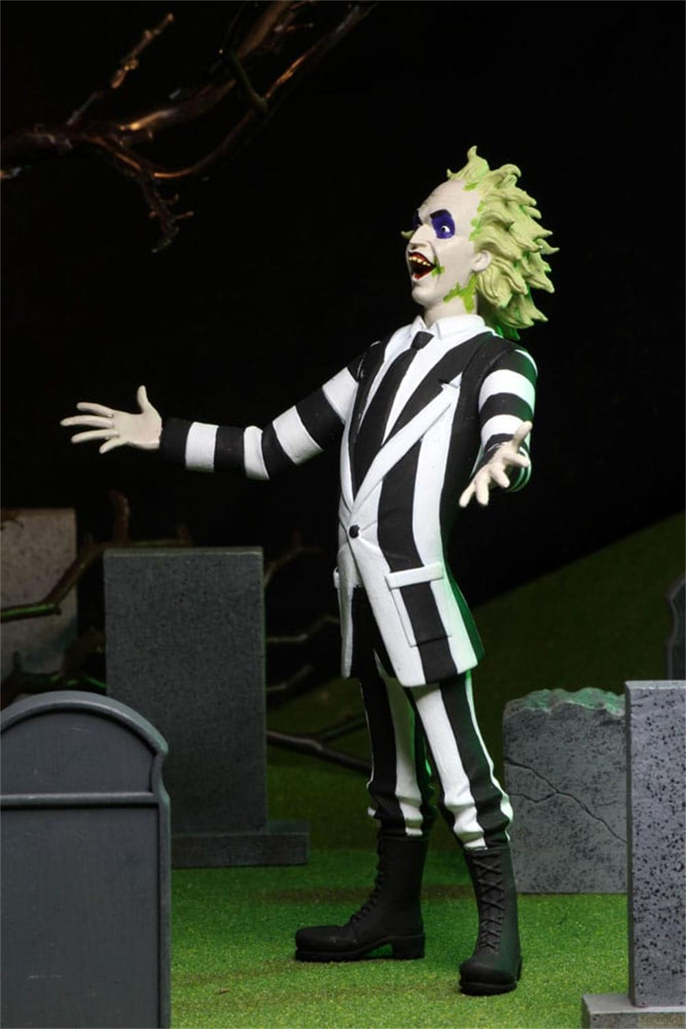 Una figura de Beetlejuice con traje blanco y negro en un cementerio.
