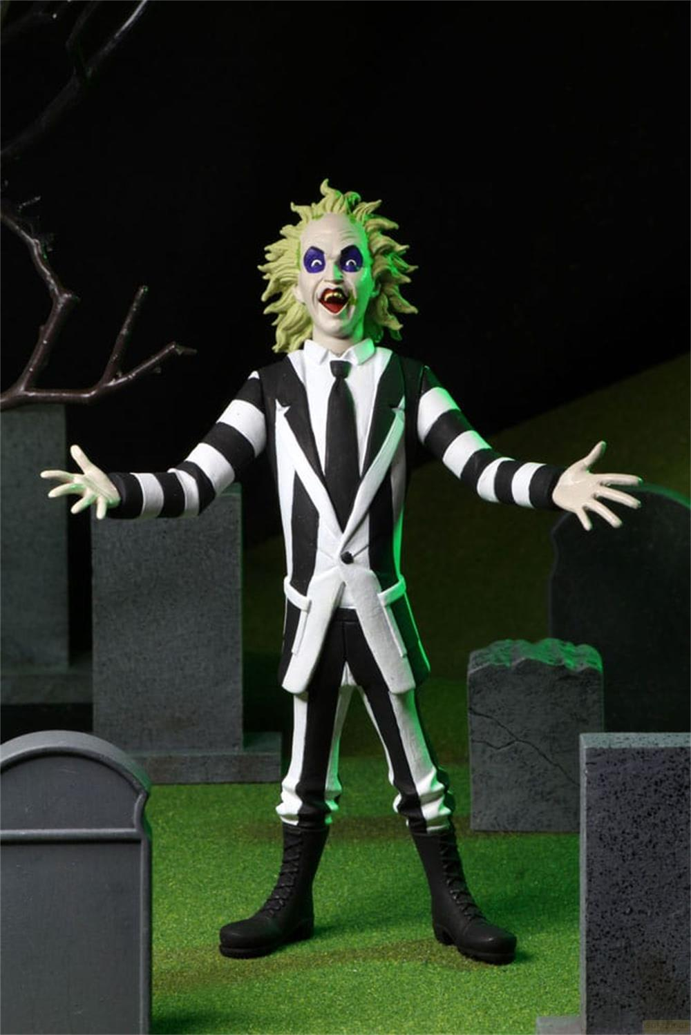 Figura de Beetlejuice con traje blanco y negro sobre césped verde con lápidas.
