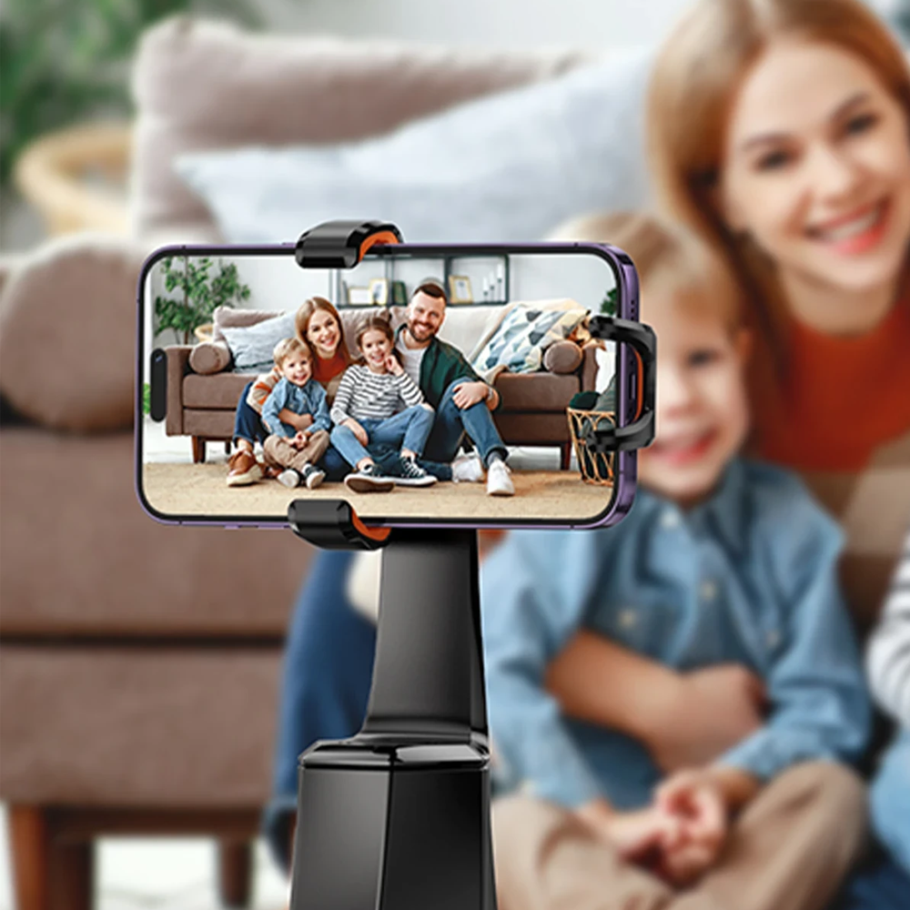 Aile oturma odasında selfie çekiyor, akıllı telefona odaklanılmış.