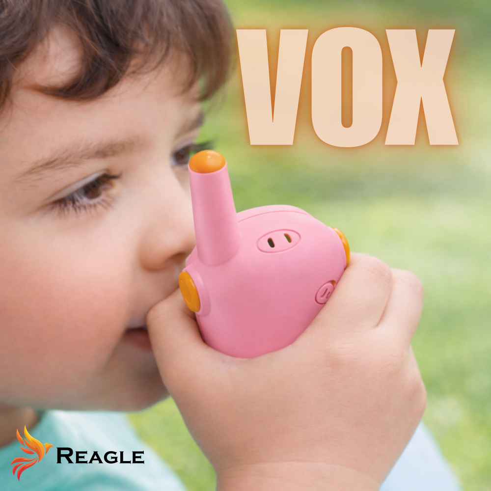 Dziecko trzyma różowy walkie-talkie z pomarańczowymi akcentami. Napis VOX.