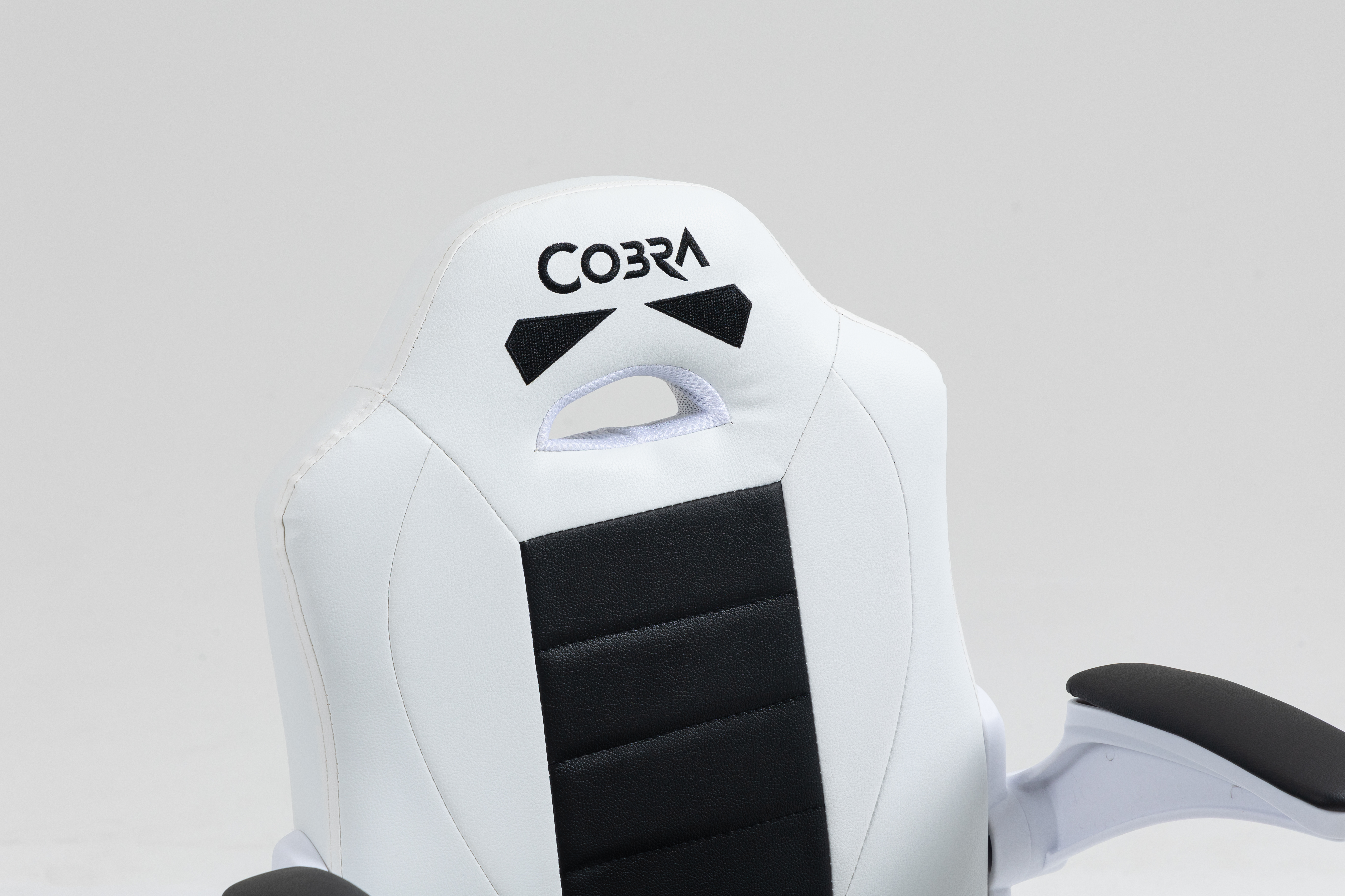 Białe krzesło gamingowe z czarną wstawką i logo Cobra.