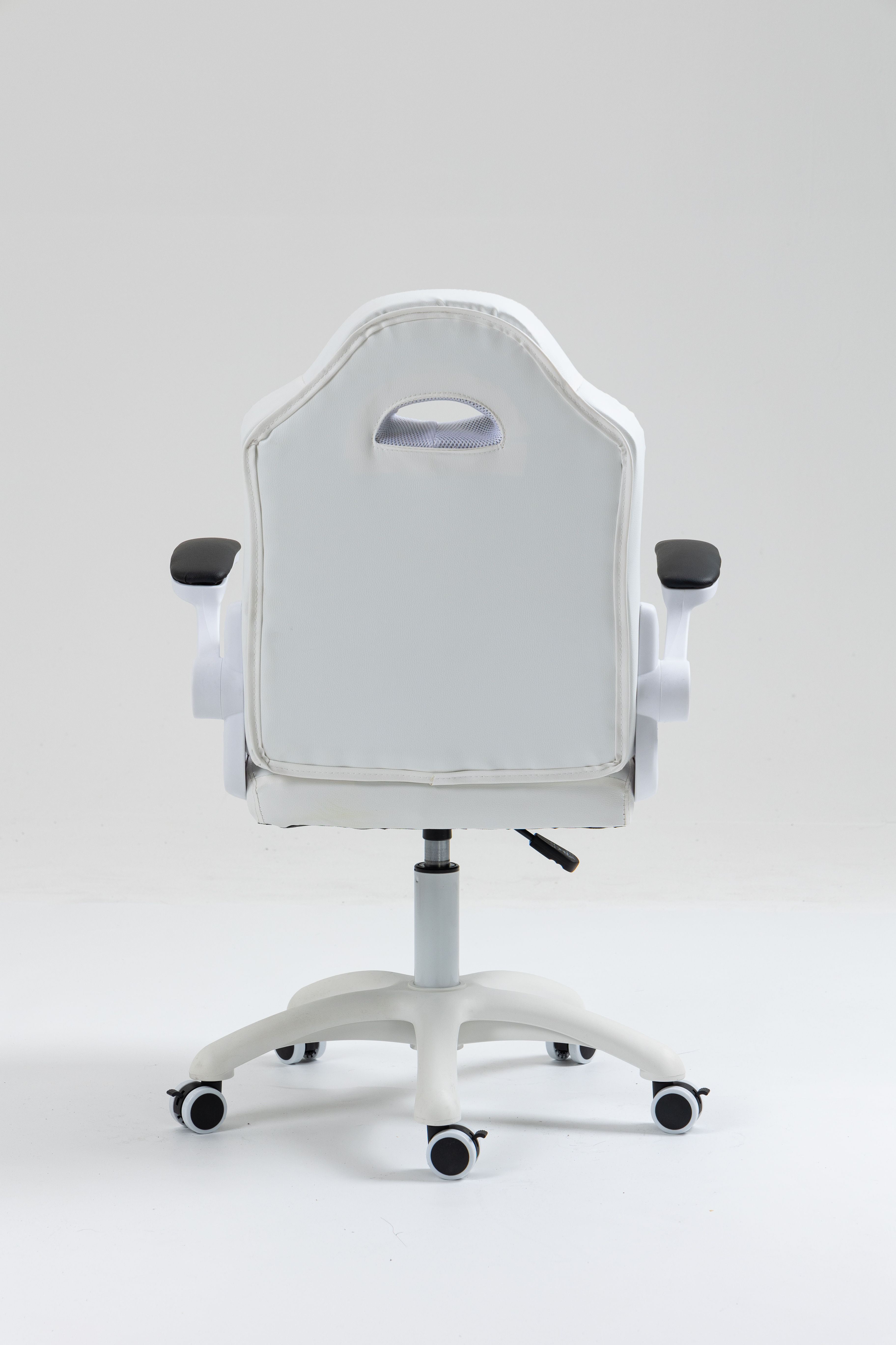 Widok z tyłu białego fotela gamingowego z czarną tapicerką i kółkami.