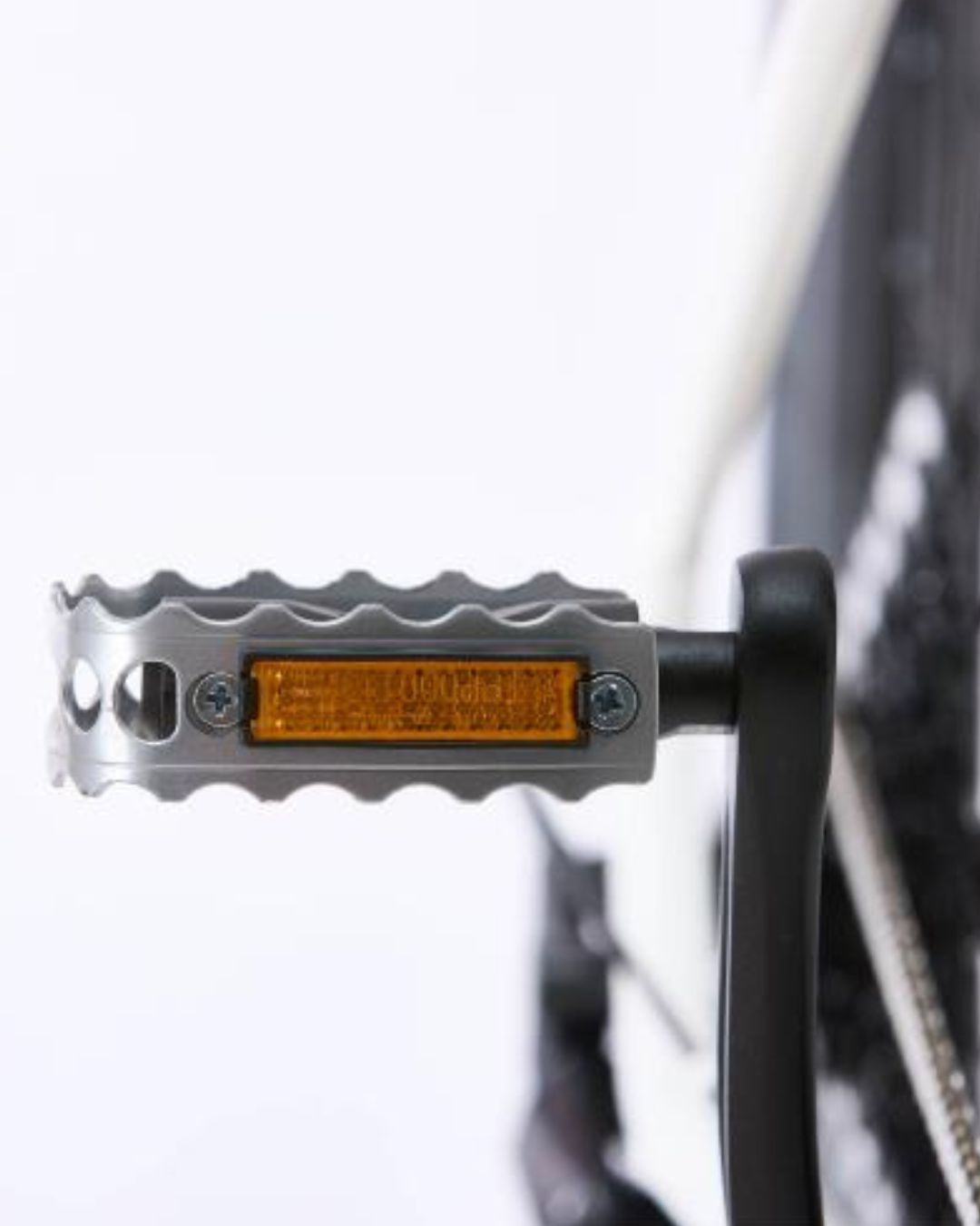 Pedale bici argento con catarifrangente arancione e pedivella nera.