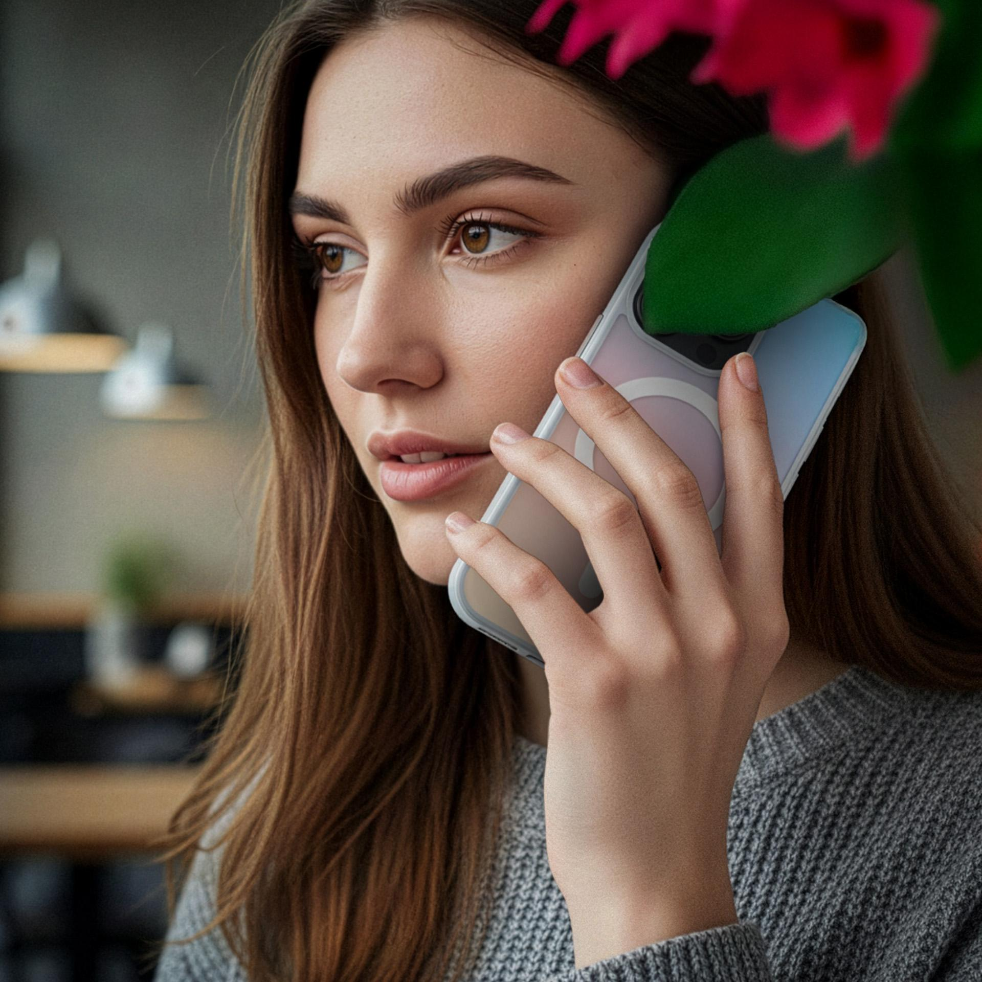 Kobieta rozmawia przez telefon, na pierwszym planie zielony liść i różowy kwiat.