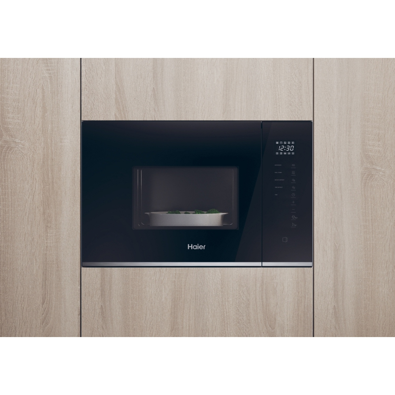Een moderne zwarte inbouwmagnetron met digitale bediening en eten in een compartiment.