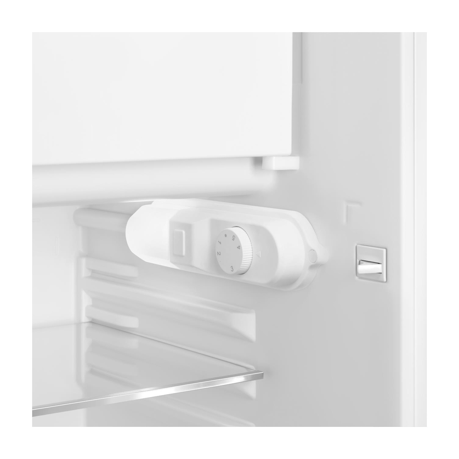 Primer plano del dial del termostato y el interruptor de luz de un refrigerador blanco.