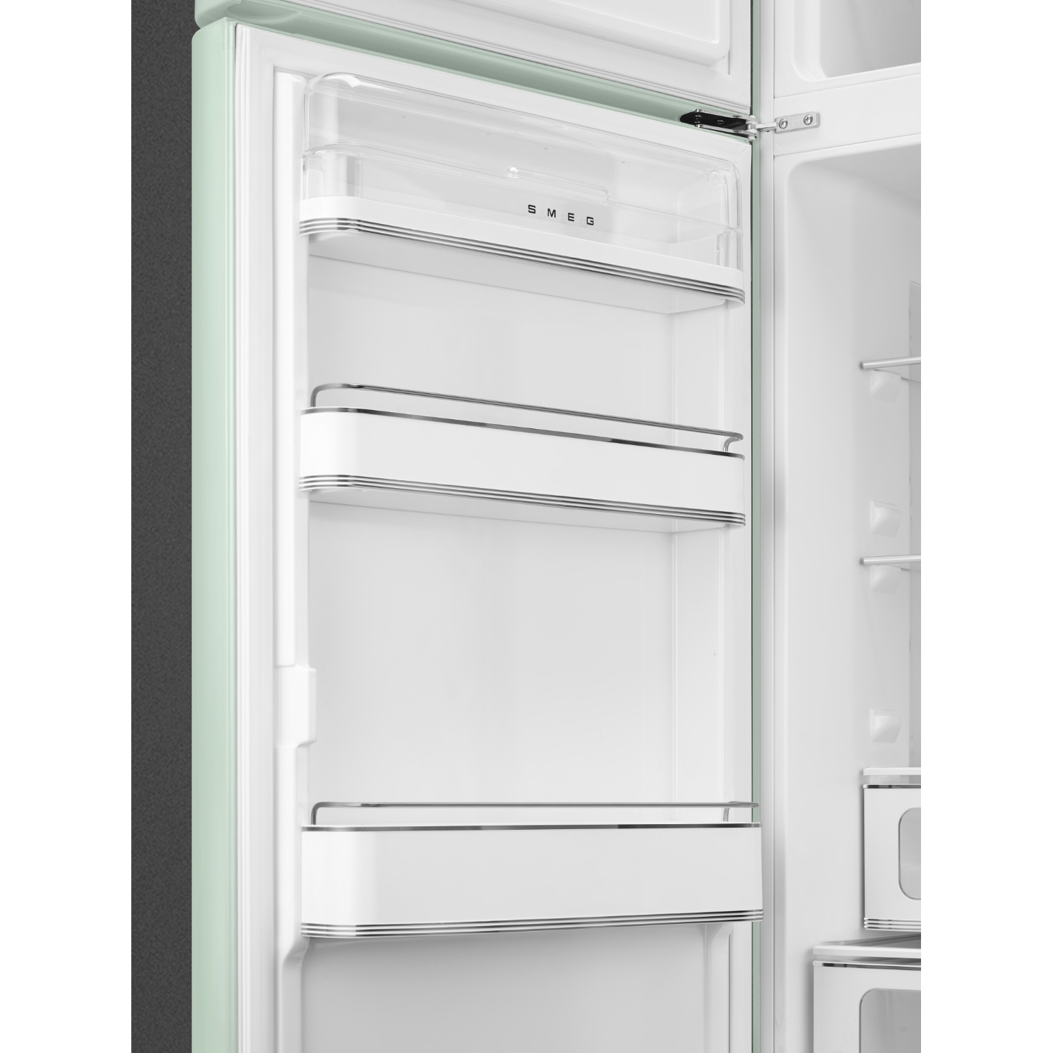 Un refrigerador abierto y de color claro con exterior verde y estantes blancos.