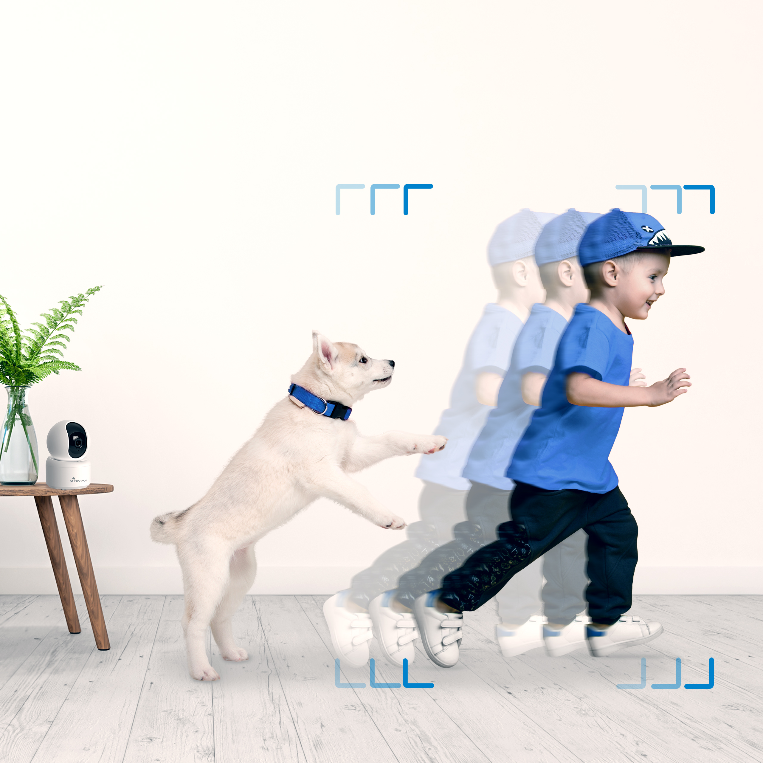 Un niño de azul corre, un perro salta. Una cámara está sobre una mesa.