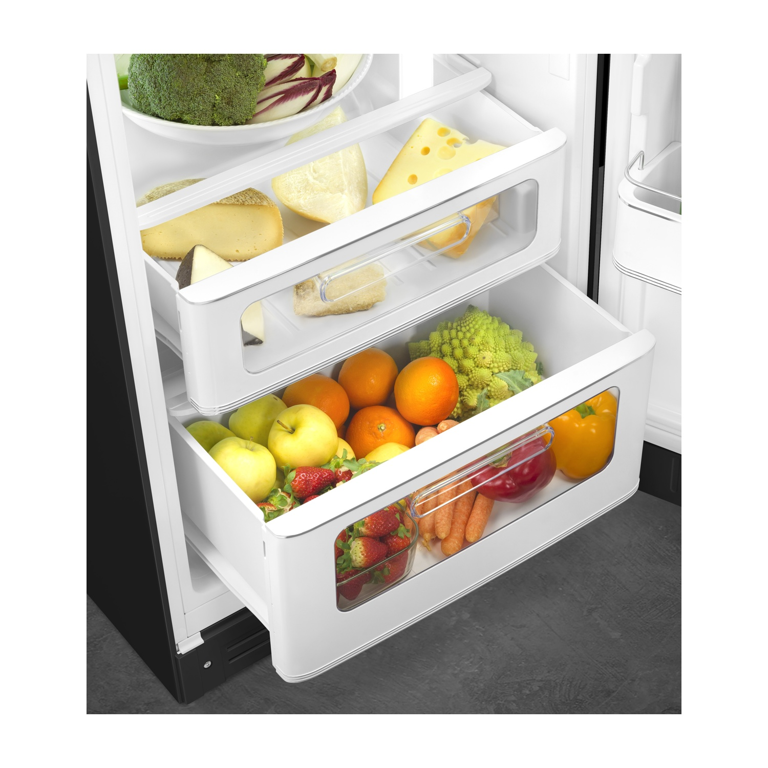 Kühlschrankfächer mit Käse, Gemüse und Obst gefüllt.
