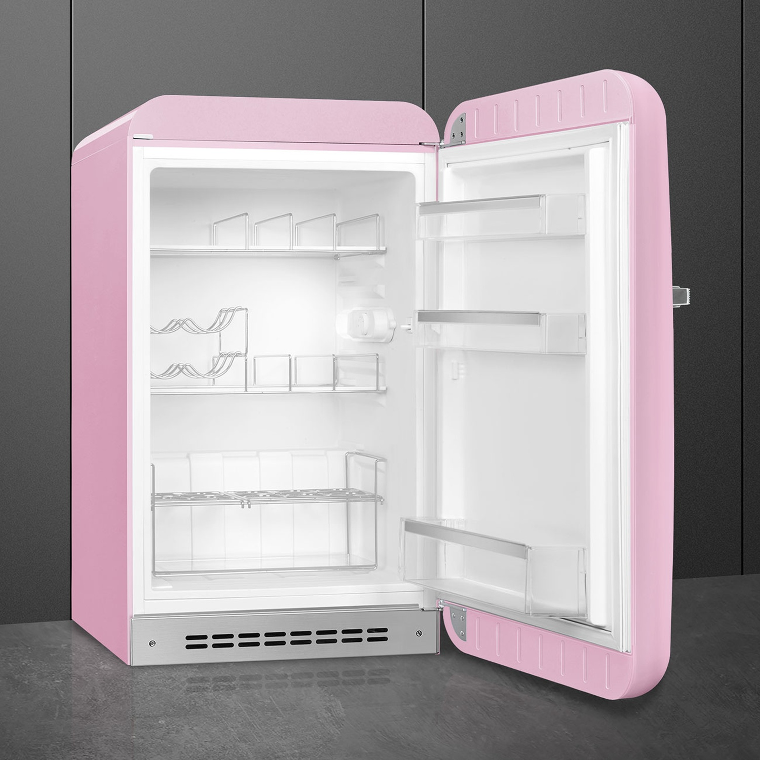 Un refrigerador rosa abierto con estantes y compartimentos sobre fondo oscuro.