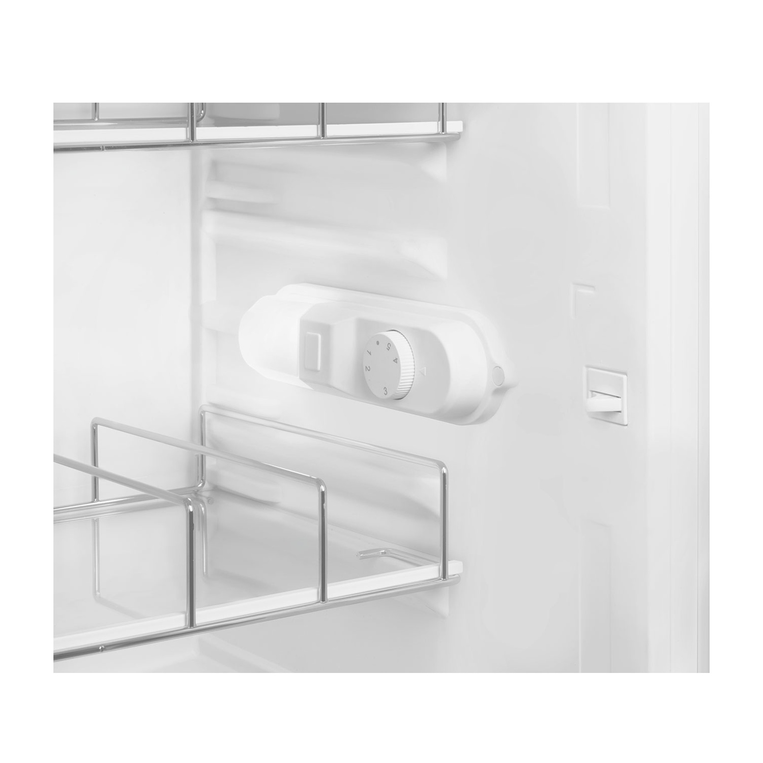 Interior de un refrigerador blanco con estantes y un dial de control de temperatura.