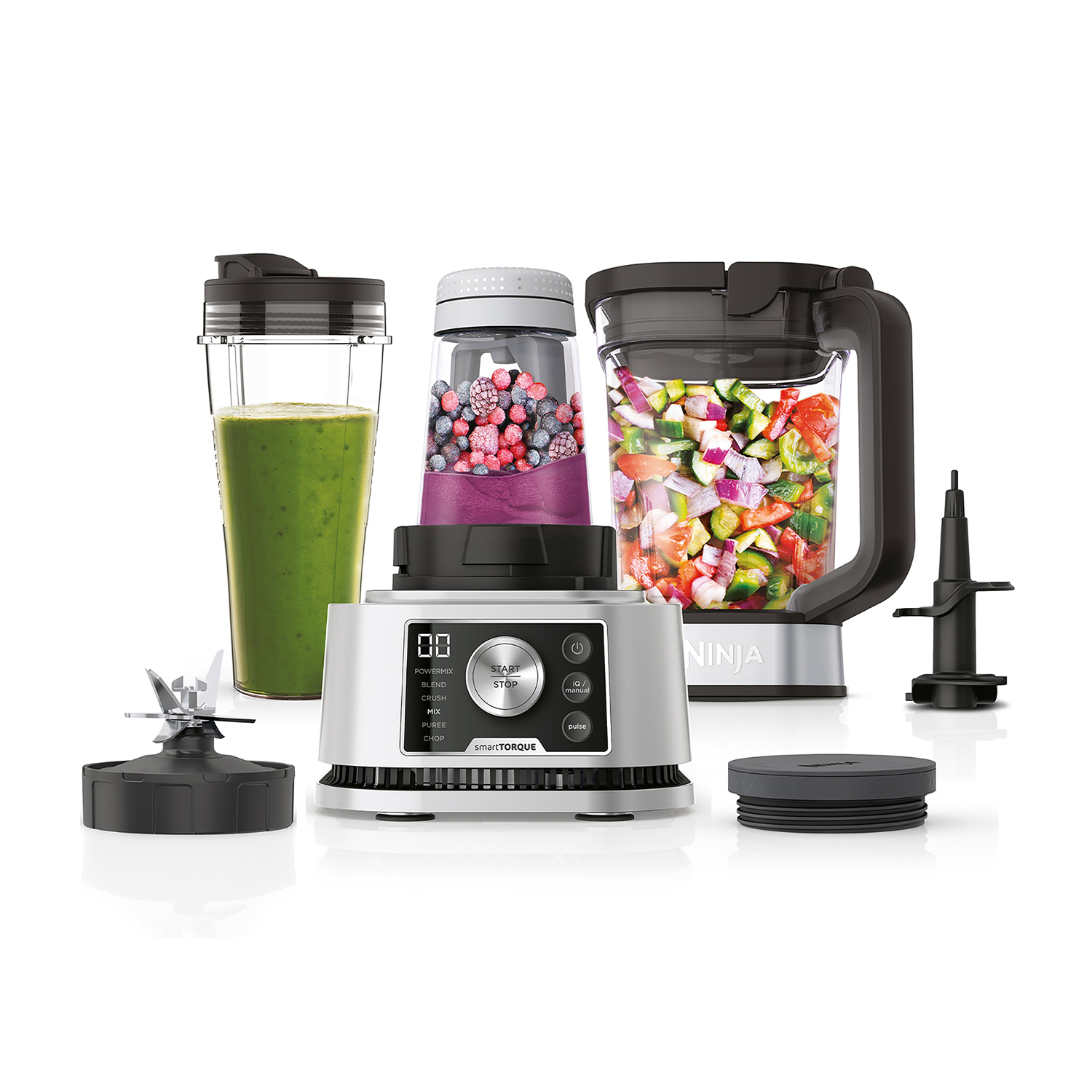 Smoothie, böğürtlen ve doğranmış sebzelerle dolu kaplara sahip Ninja blender.