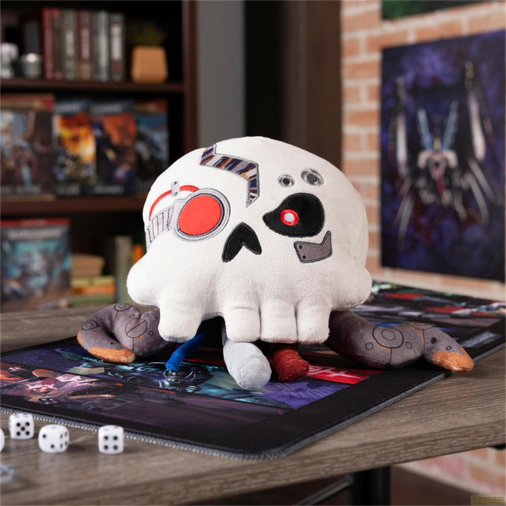 Un peluche a forma di teschio bianco con dettagli rossi e neri su un tappetino da gioco.