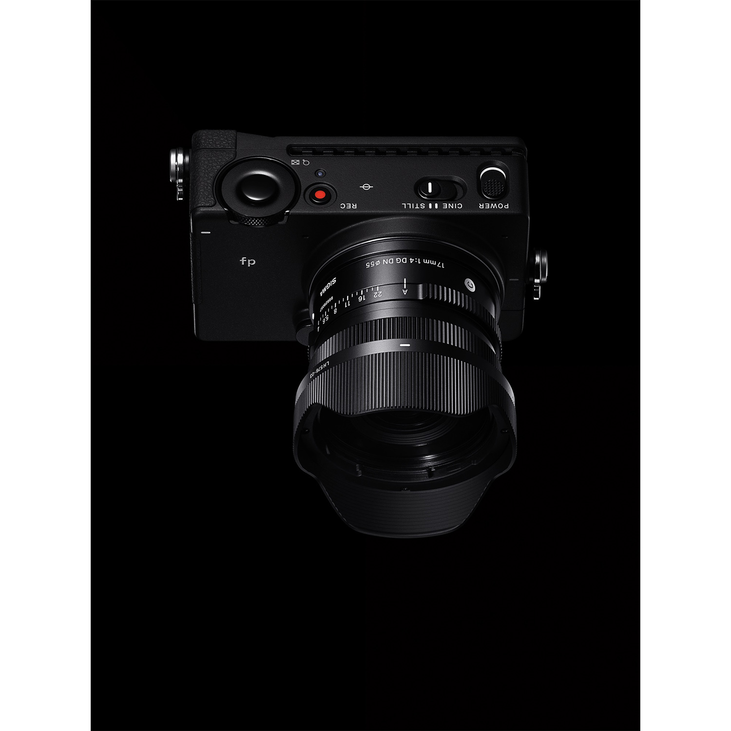 Czarny aparat z obiektywem 17mm, pierścieniem ostrości i elementami sterującymi na czarnym tle.