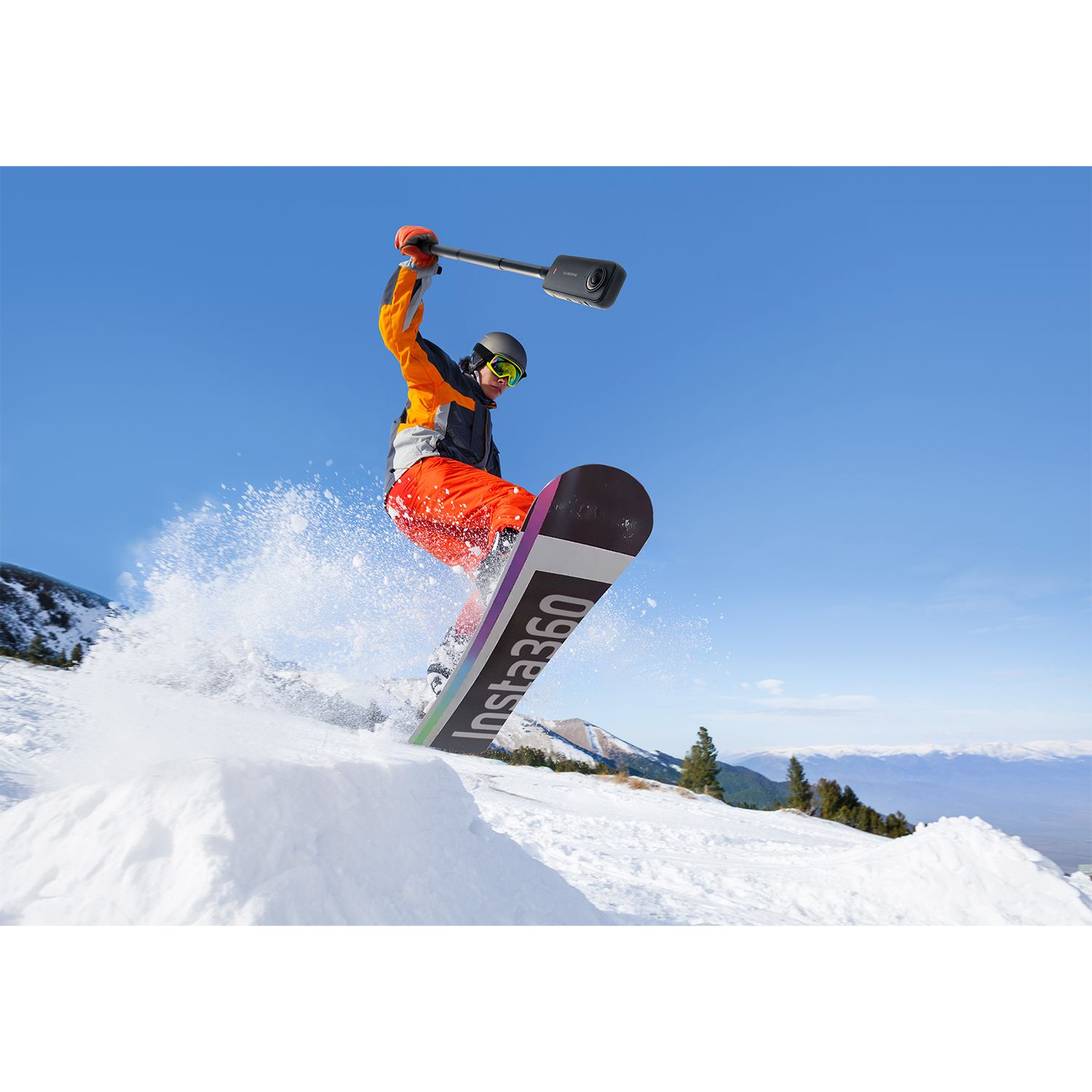 Snowboarder skacze w powietrzu, trzymając nad sobą kamerę.