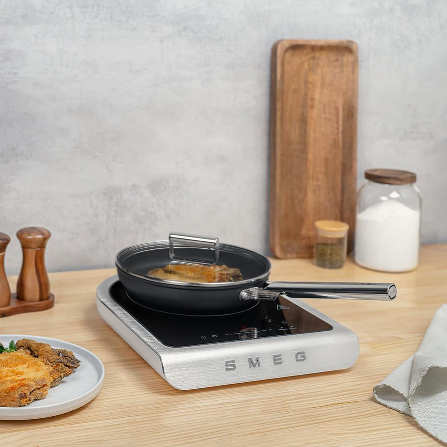 Filet ryby smaży się na patelni na płycie indukcyjnej SMEG.