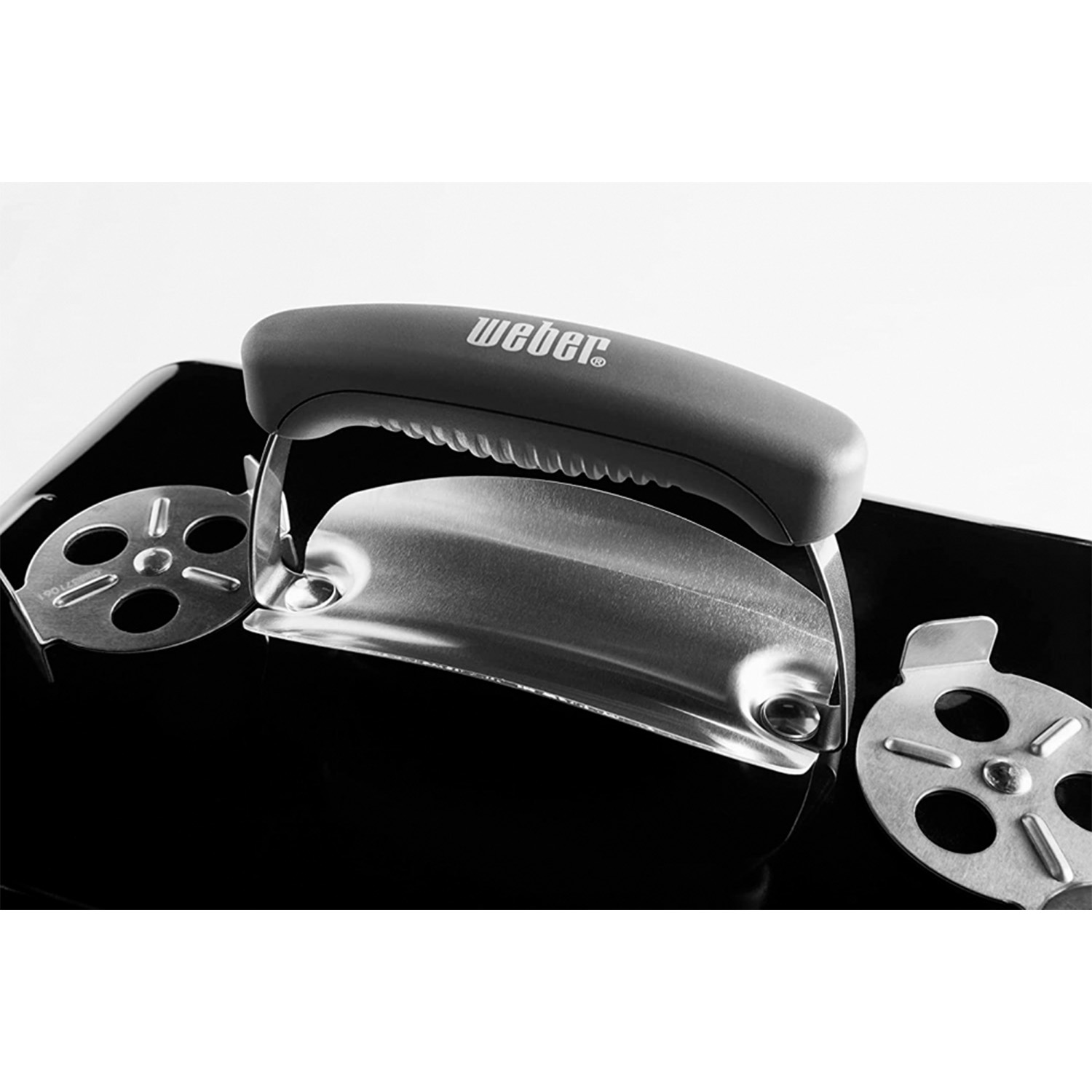 Czarny grill z srebrną rączką i otworami wentylacyjnymi.