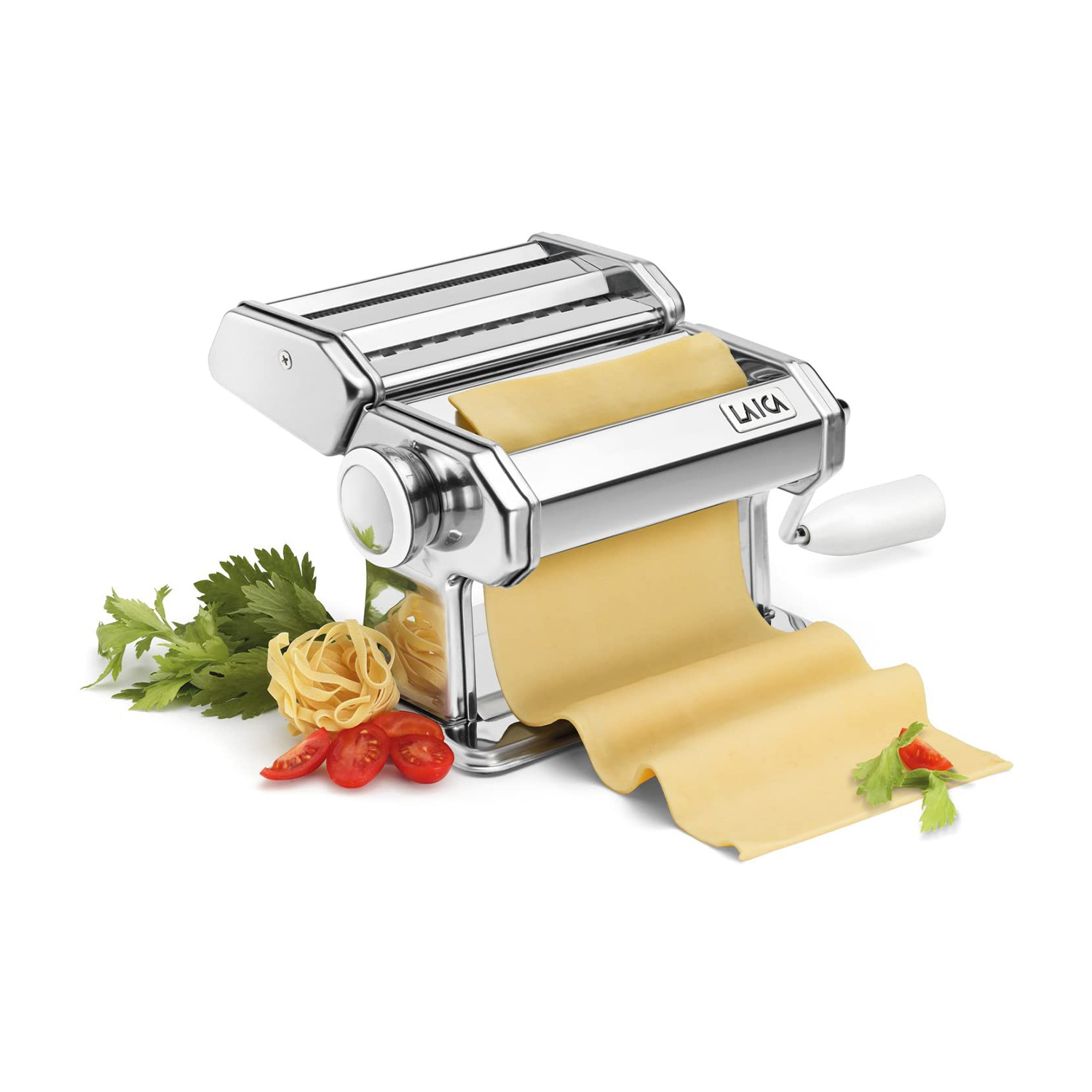 Eine glänzende Metall-Nudelmaschine mit frischem Nudelteig, Fettuccine und Kirschtomaten.
