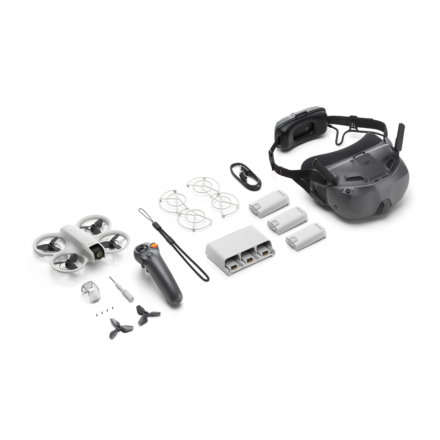 Ein weißer Mini-Drohne-Kit mit Brille, Fernbedienung, Akkus, Propellern und Werkzeug.