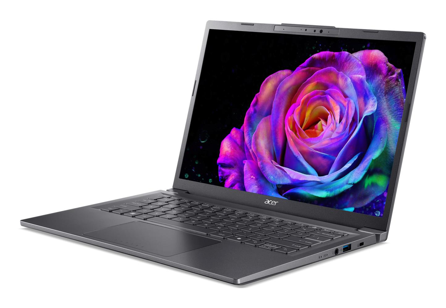 Otwarty laptop wyświetla kolorową różę na ekranie na czarnym tle.