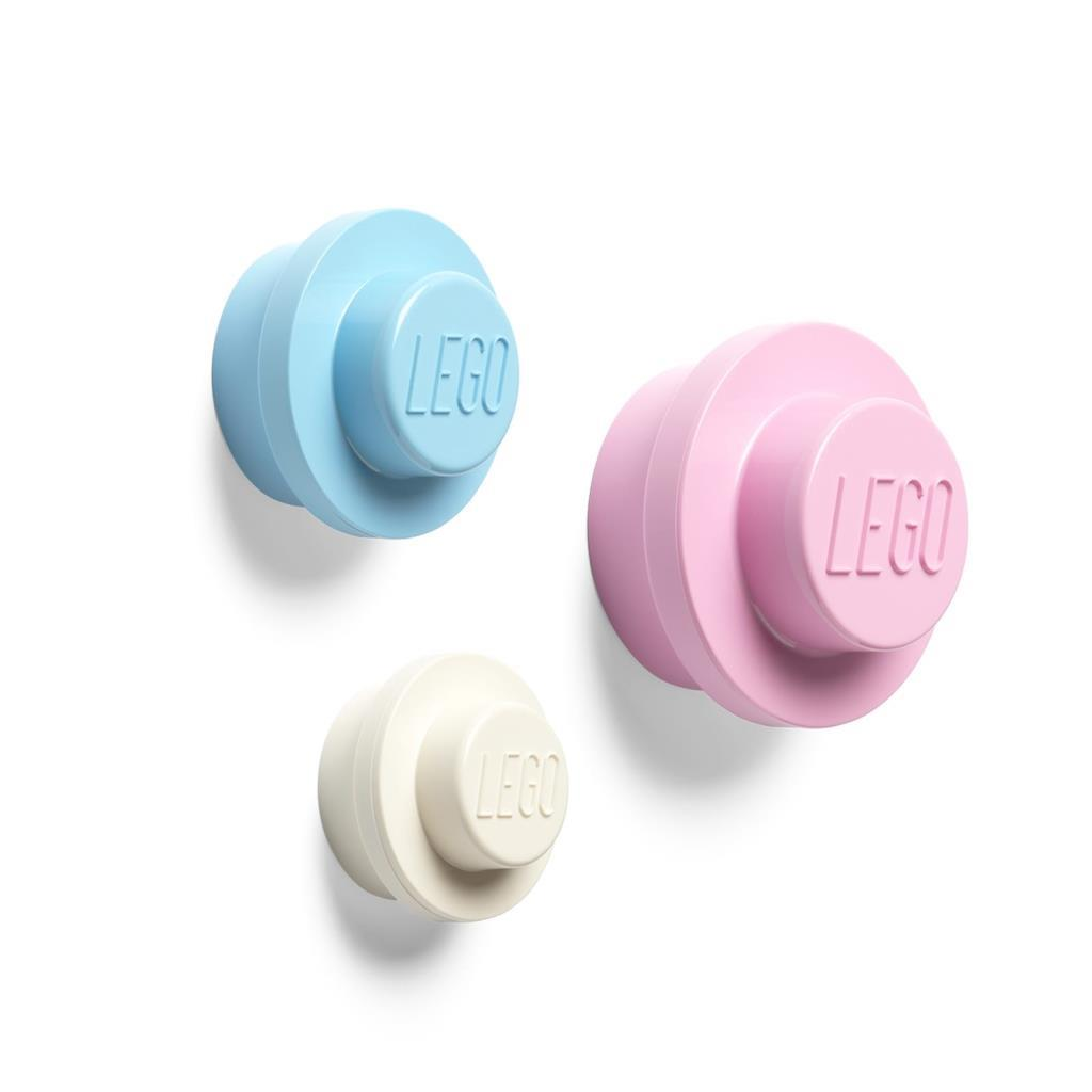 Tre ganci rotondi LEGO blu, rosa e crema, su sfondo bianco.