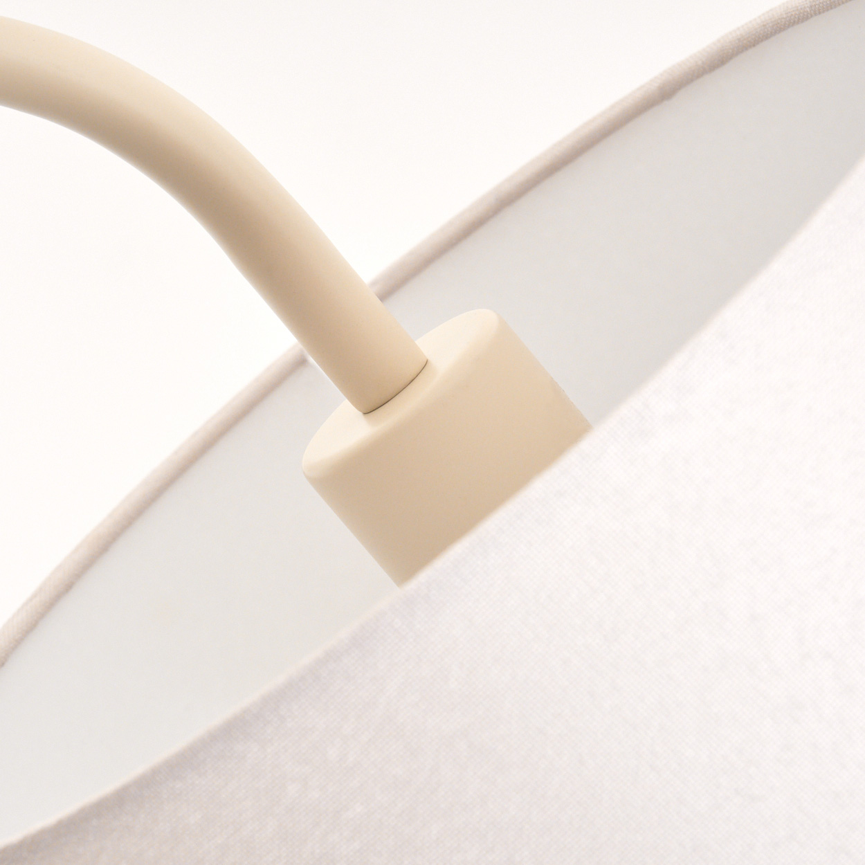 Beige Lampenarm und Lampenschirm aus Stoff im Detail, weißer Hintergrund.