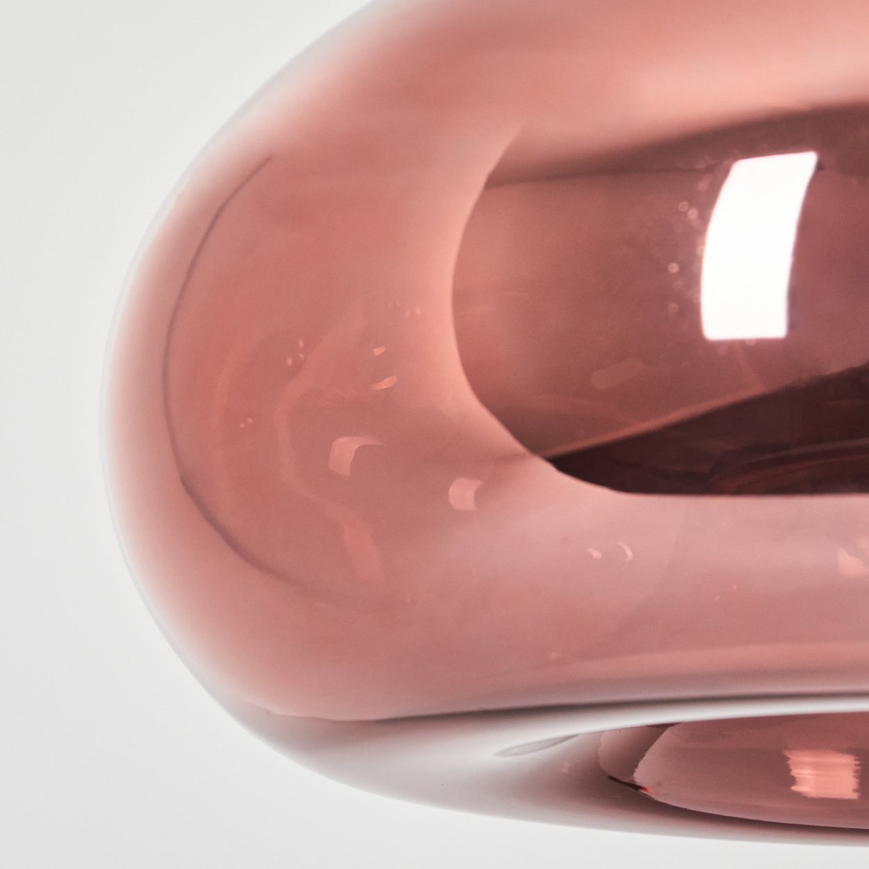 Eine Nahaufnahme einer rosafarbenen Glaslampe mit reflektierendem Licht.