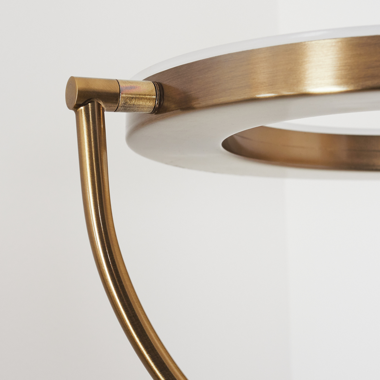 Messingdetails einer runden Lampe mit weißem Licht.
