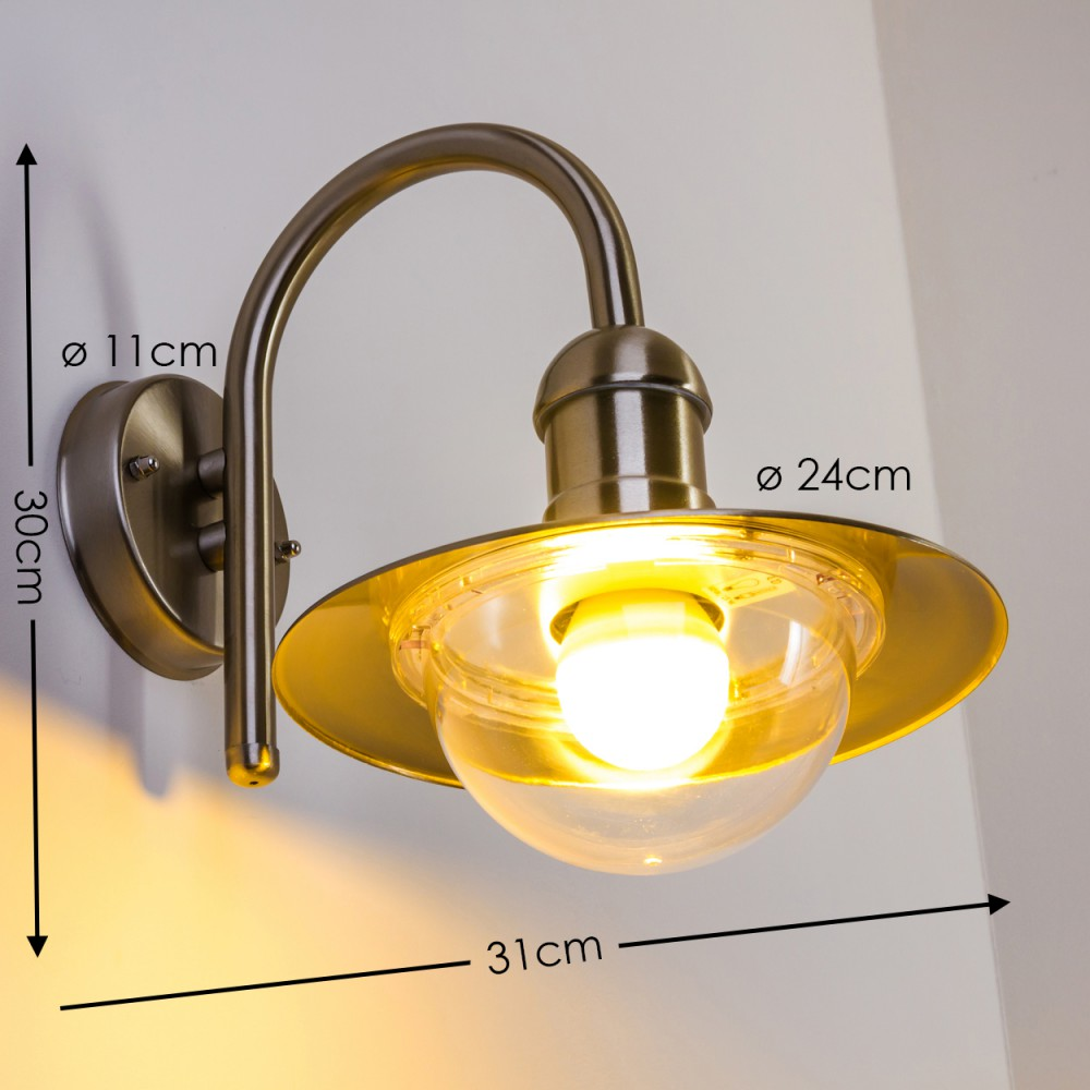 Eine Wandleuchte mit Metallarm, Glaskuppel und goldfarbenem Schirm.