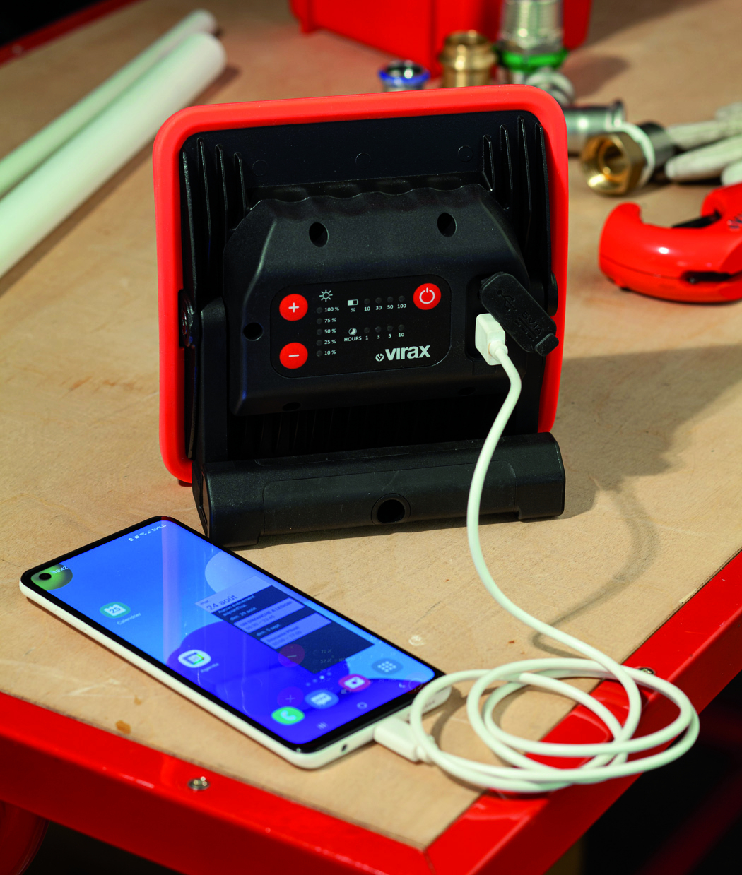 Ein tragbares Licht wird aufgeladen, während es einen Smartphone speist.