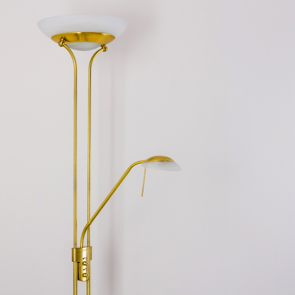 Eine goldene Stehlampe mit zwei Lichtern vor einer weißen Wand.