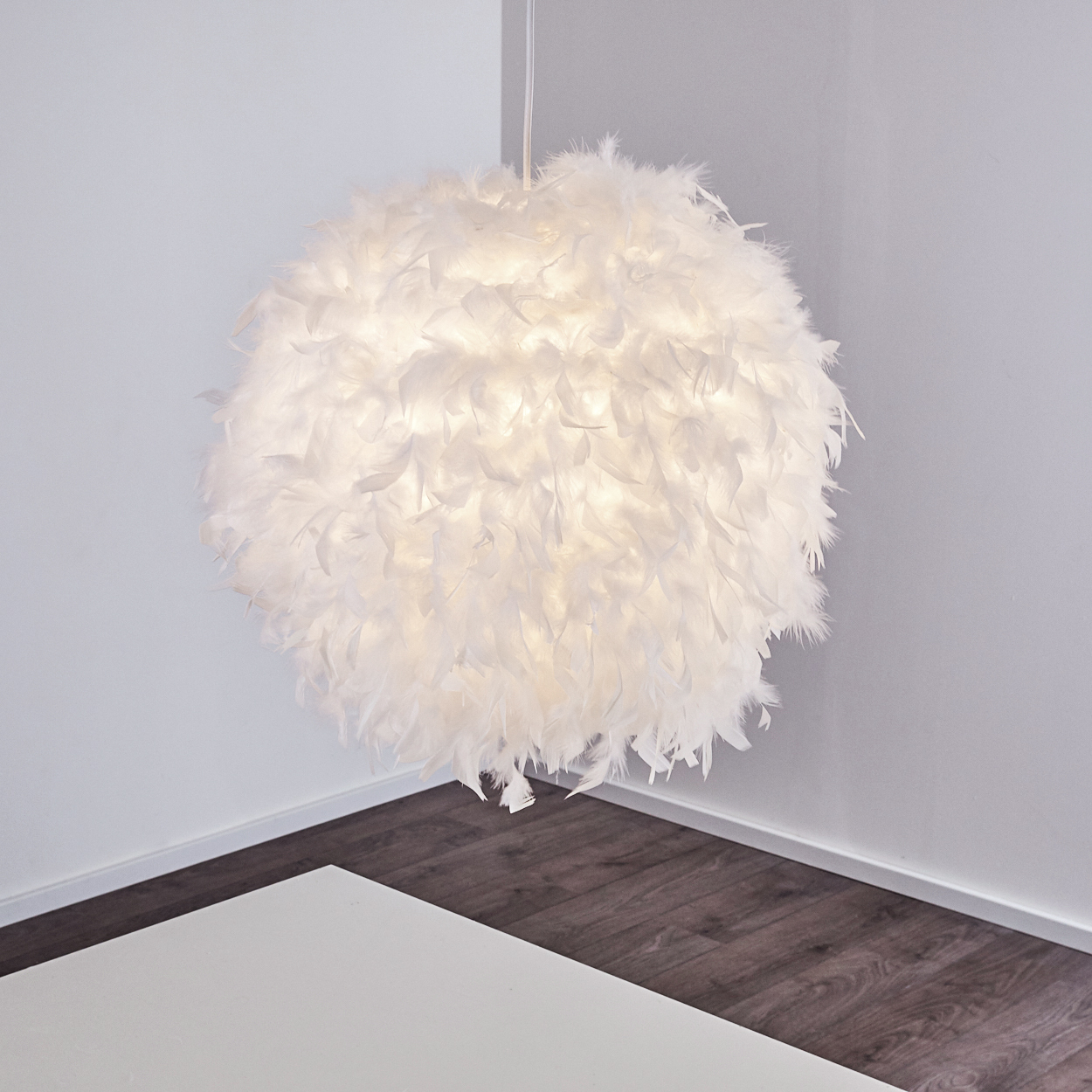 Eine weiße Federlampe hängt von der Decke, beleuchtet von innen.