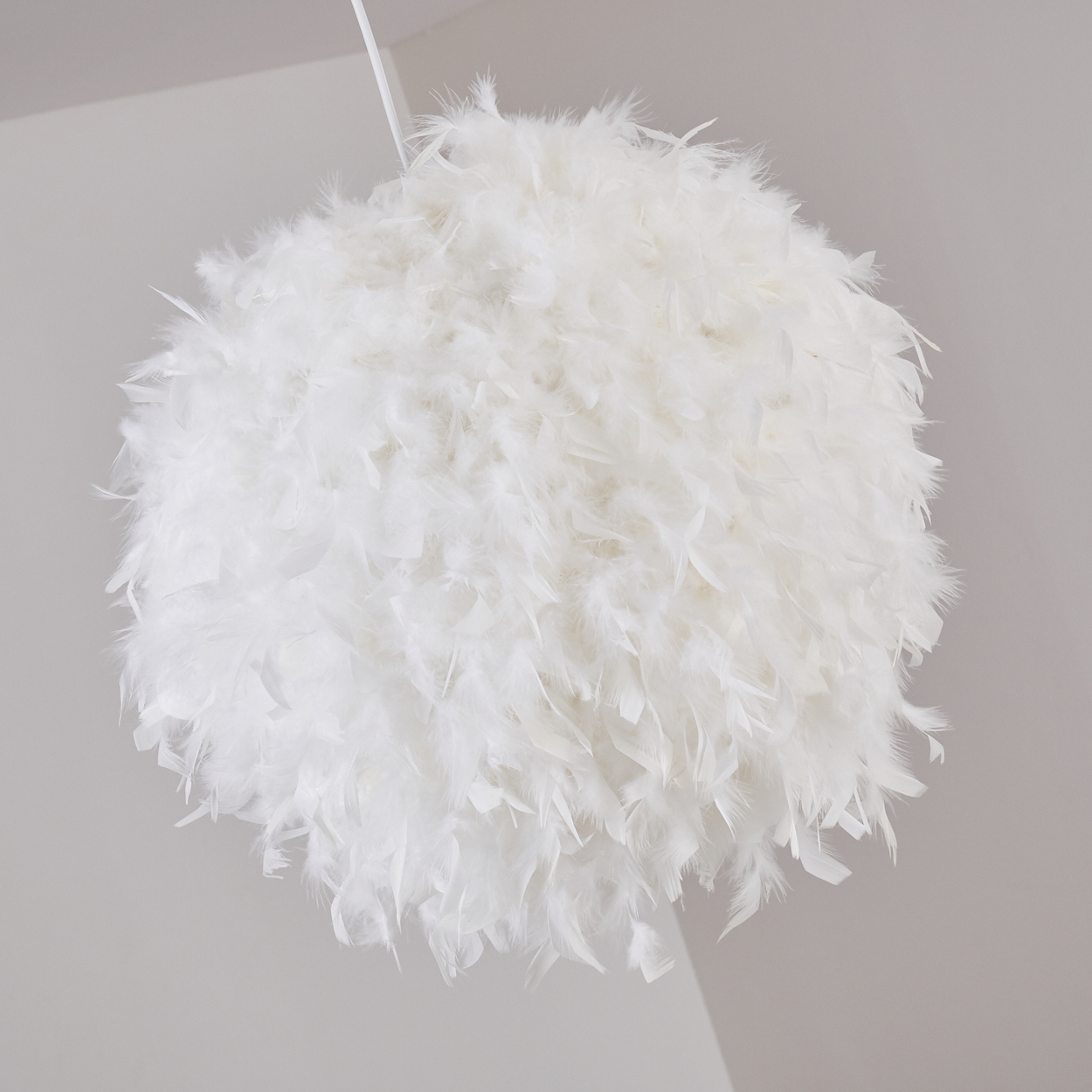 Eine kugelförmige weiße Federlampe hängt von der Decke.