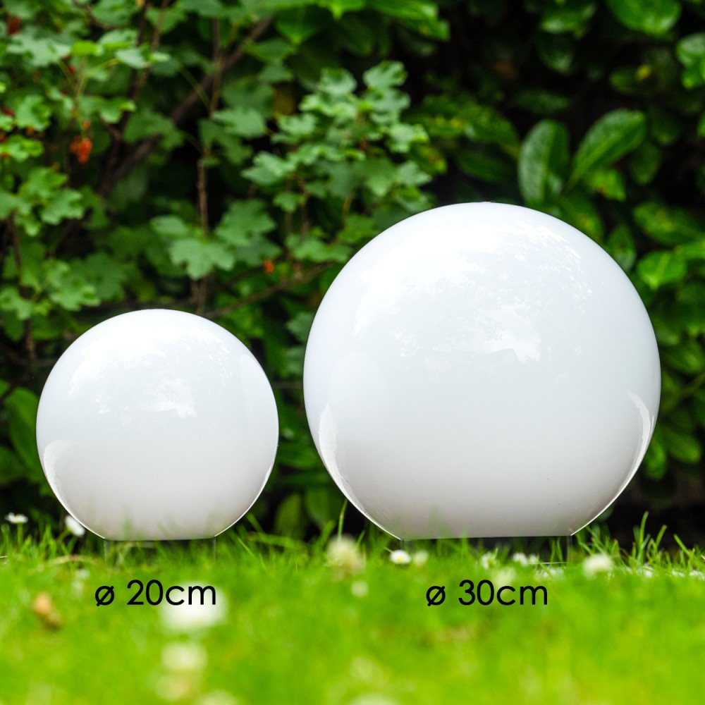 Zwei weiße Kugelleuchten, Ø 20cm und 30cm, im Gras vor grünem Laub.