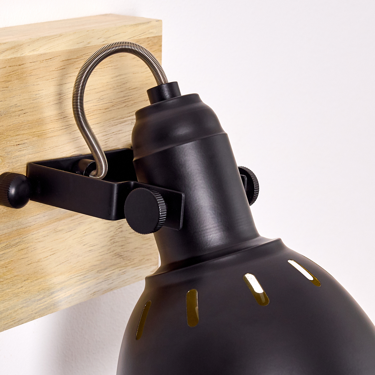 Eine schwarze Lampe mit flexiblem Arm an einem Holzbrett montiert.